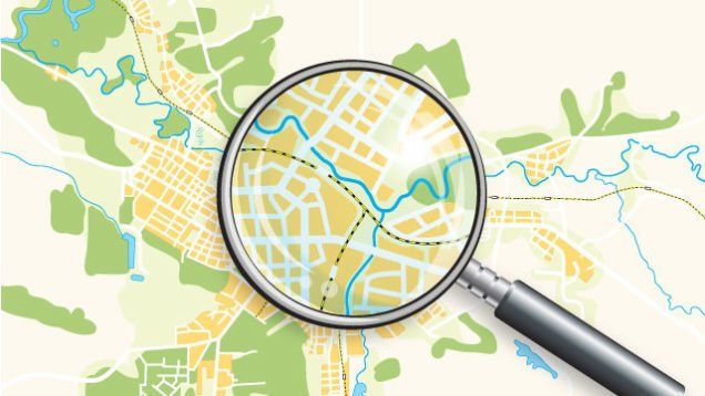 A magnifying glass is looking at a map of a city.
