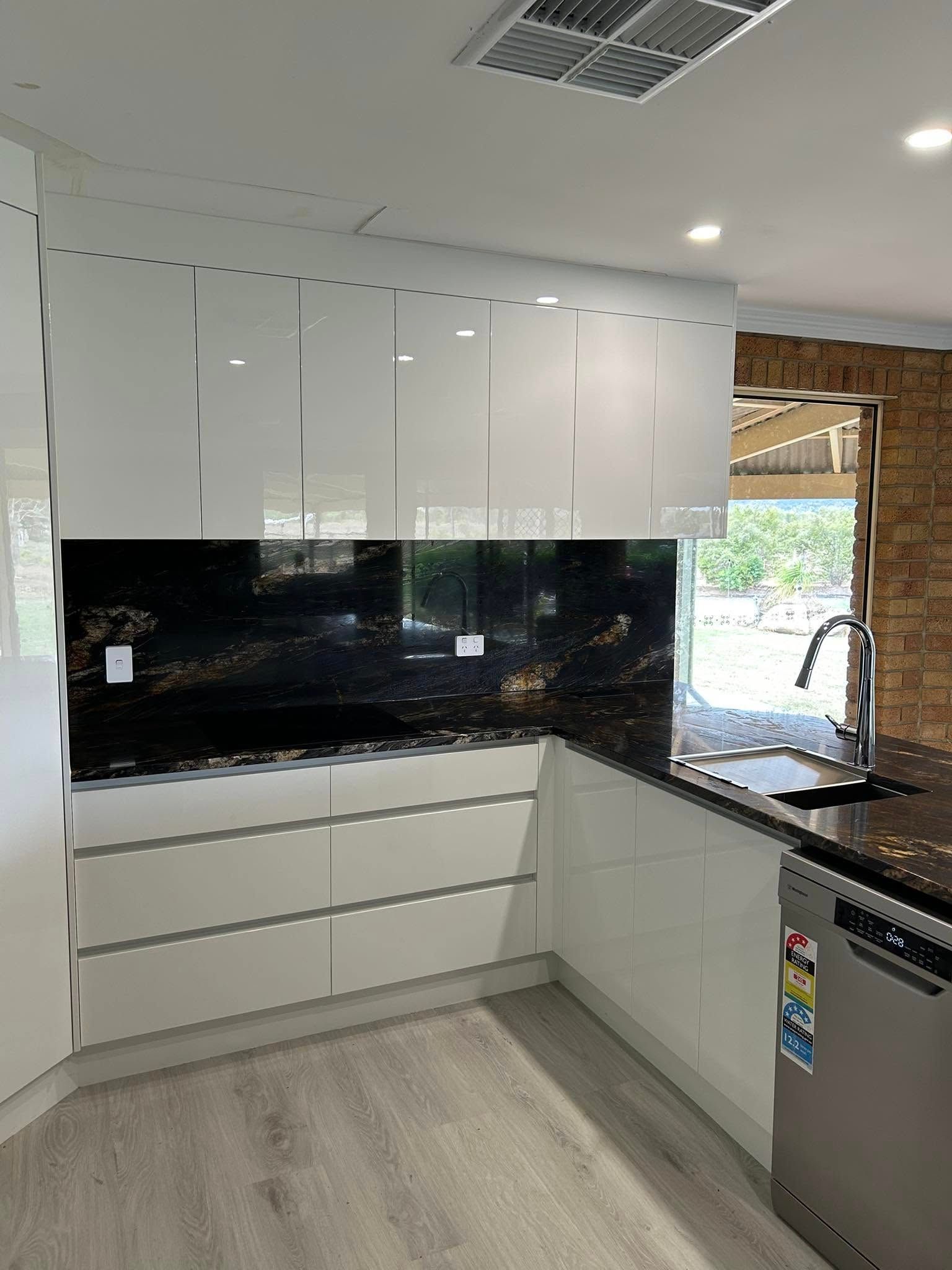 Modern White Kitchen with Black Granite Backsplash and Countertops — Valley Cabinetmakers In Biloela, QLD 