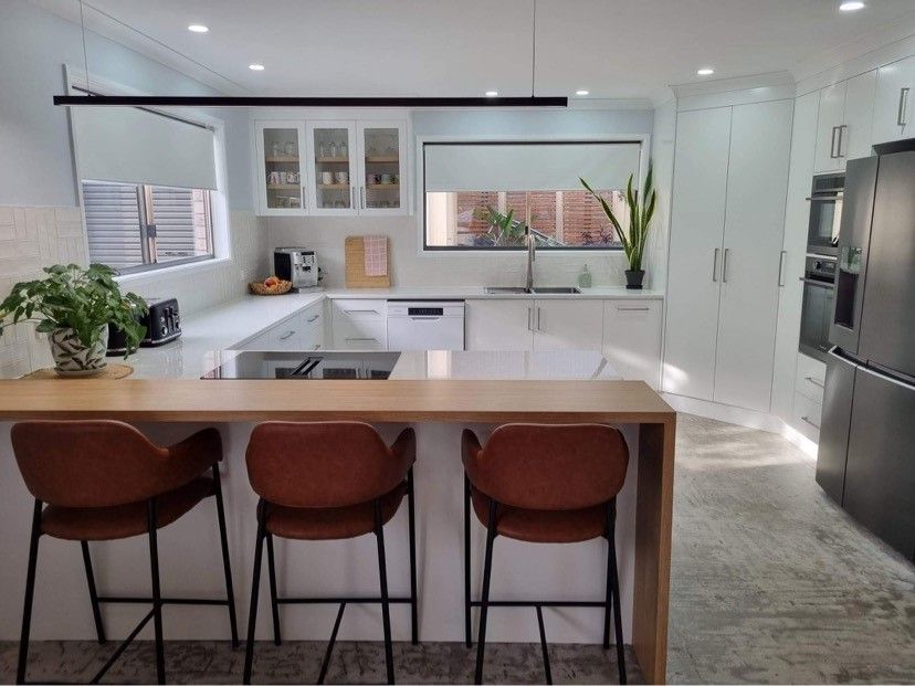 Elegant White Kitchen with Island, Marble Countertops, Wooden Floors, and Chandelier — Valley Cabinetmakers In Biloela, QLD 