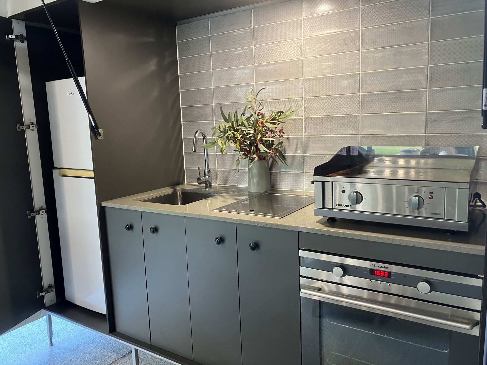 White kitchen with island, cabinets, and a plant in a white vase on the countertop— Valley Cabinetmakers In Biloela, QLD 