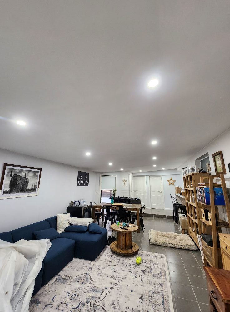 Living Room With Blue Sectional Dining Table on Tiled Floor — Wetzel Electrical in Dapto, NSW