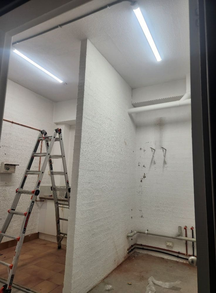 Interior View of a Small Room Under Construction With a Ladder and Lights — Wetzel Electrical in Wollongong, NSW