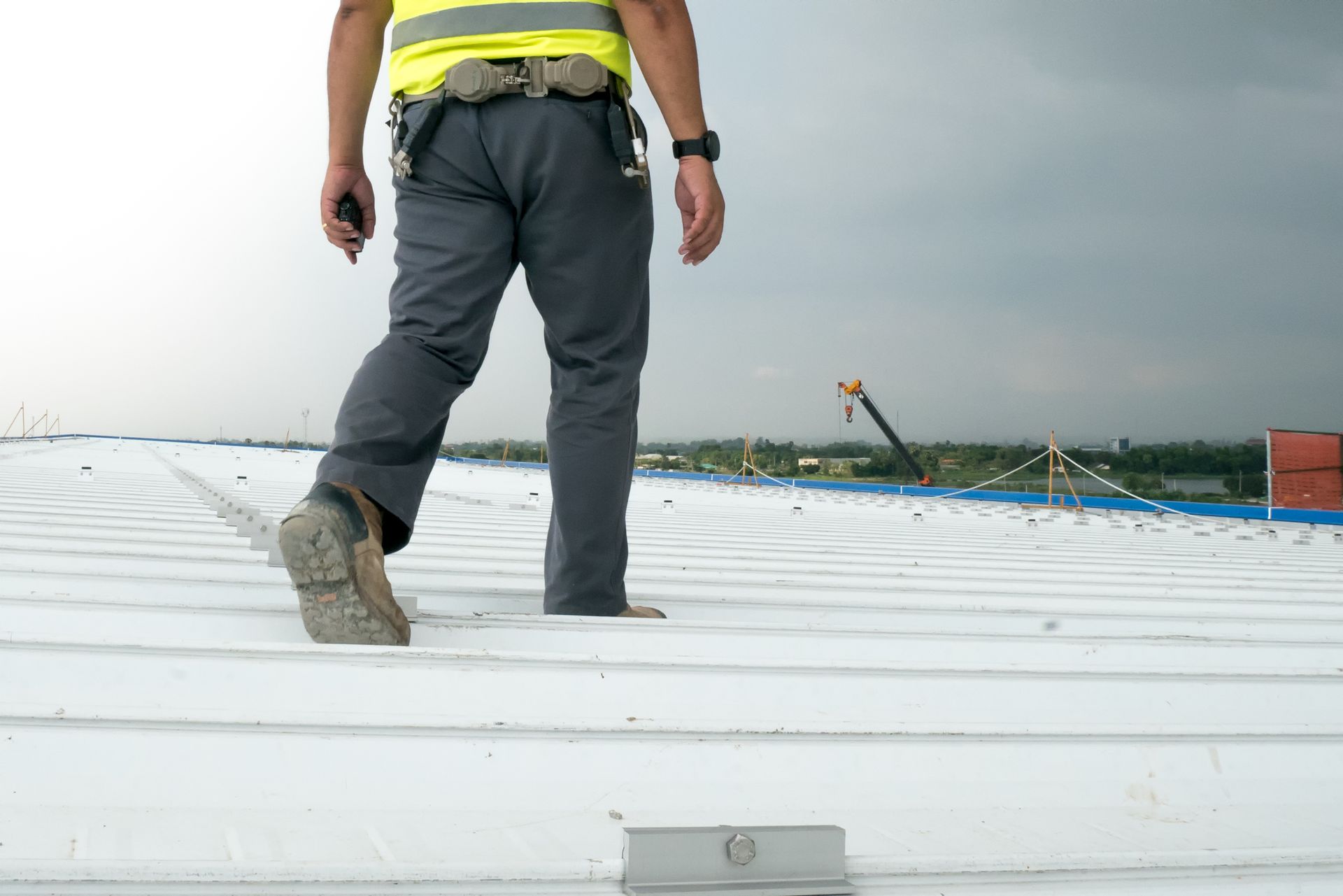 A man is walking on a white roof.