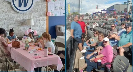A group of people are sitting at a table with a pink table cloth.