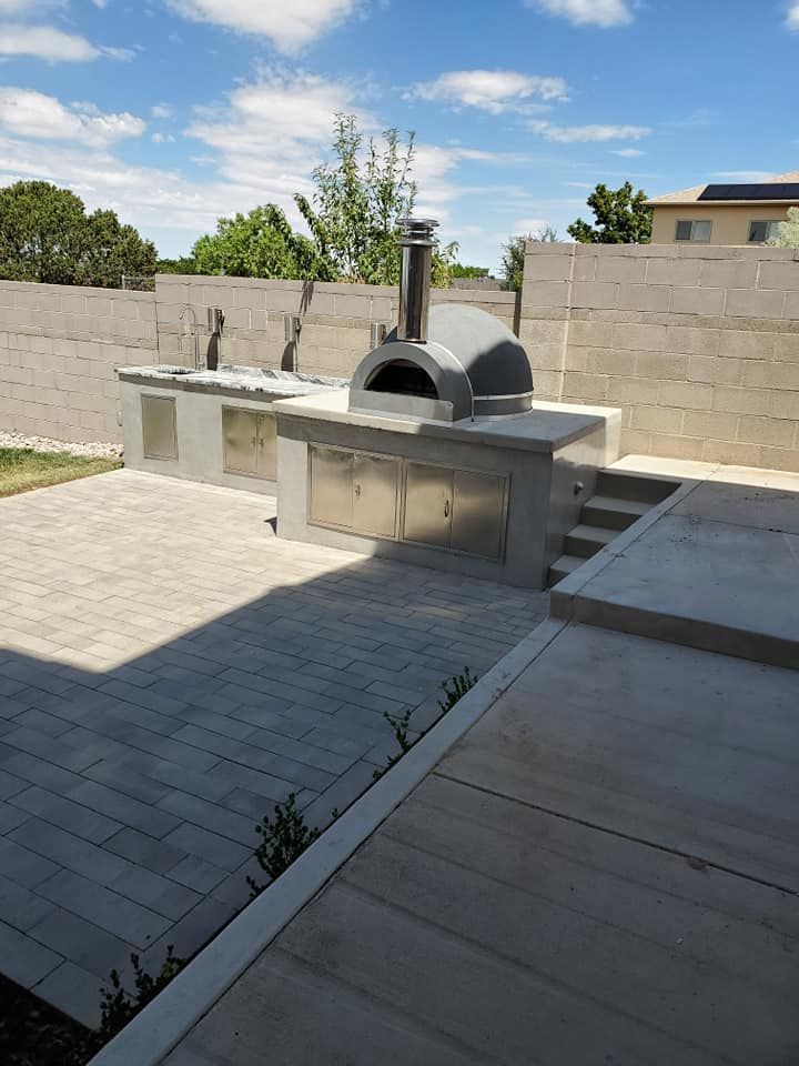 An outdoor kitchen with a pizza oven in the middle