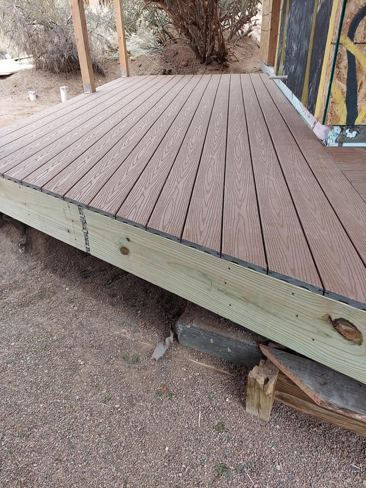 A wooden deck is sitting on the ground next to a building.