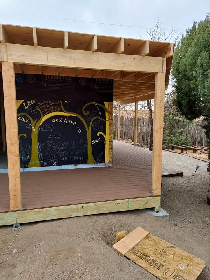 A wooden structure with a chalkboard on the side of it.