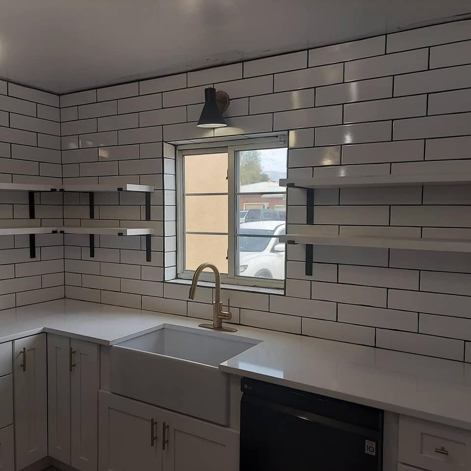 A kitchen with white brick walls and a sink