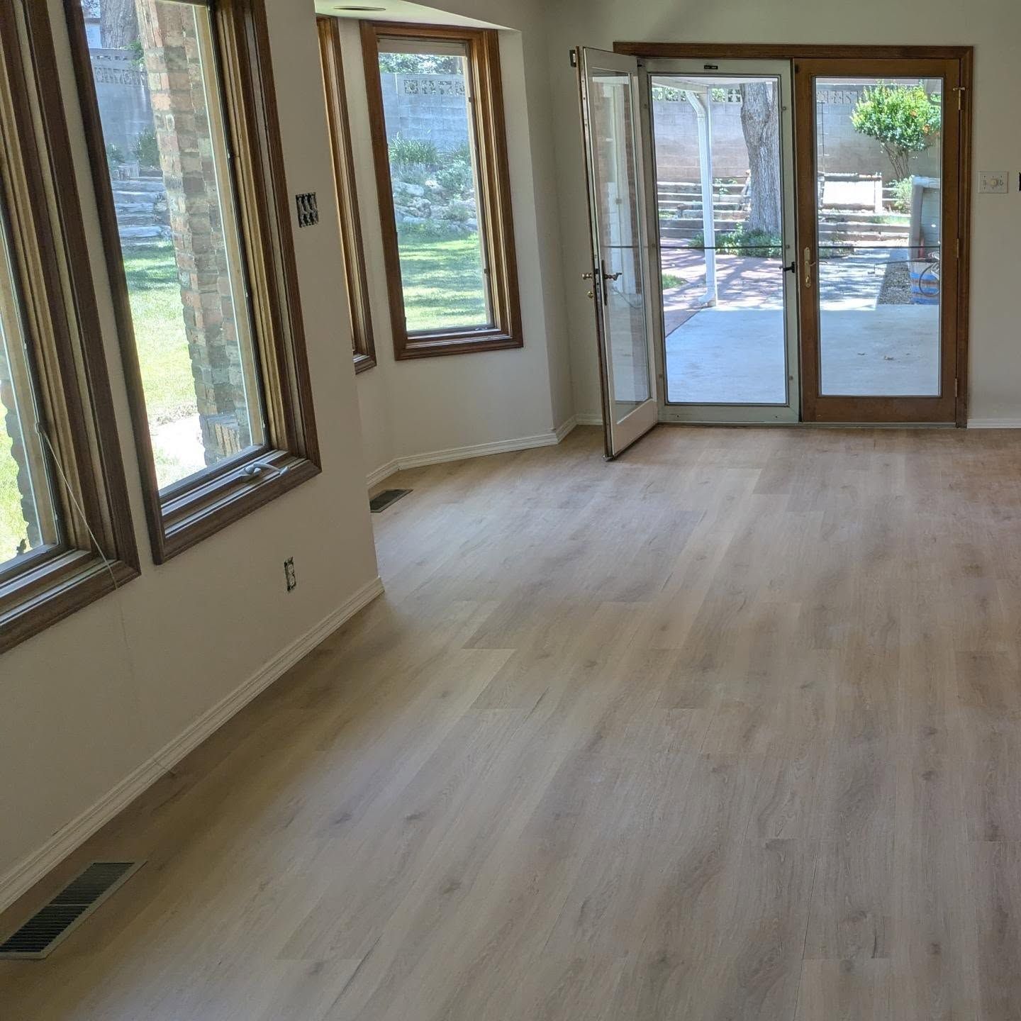 A living room with hardwood floors and a sliding glass door.
