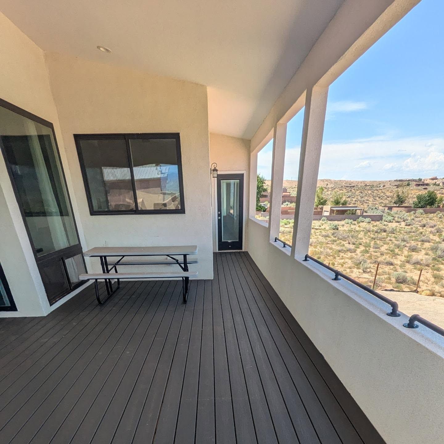 A porch with a picnic table and a window