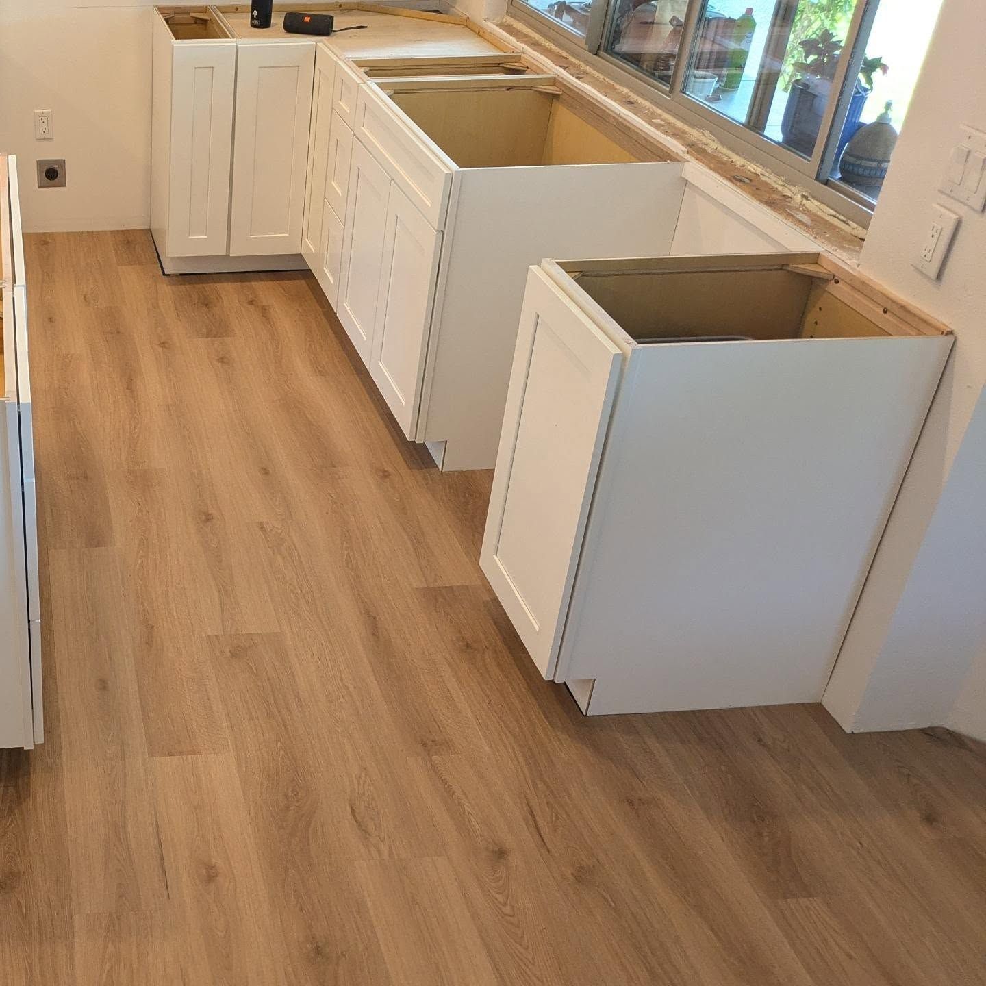 A kitchen with wooden floors and white cabinets
