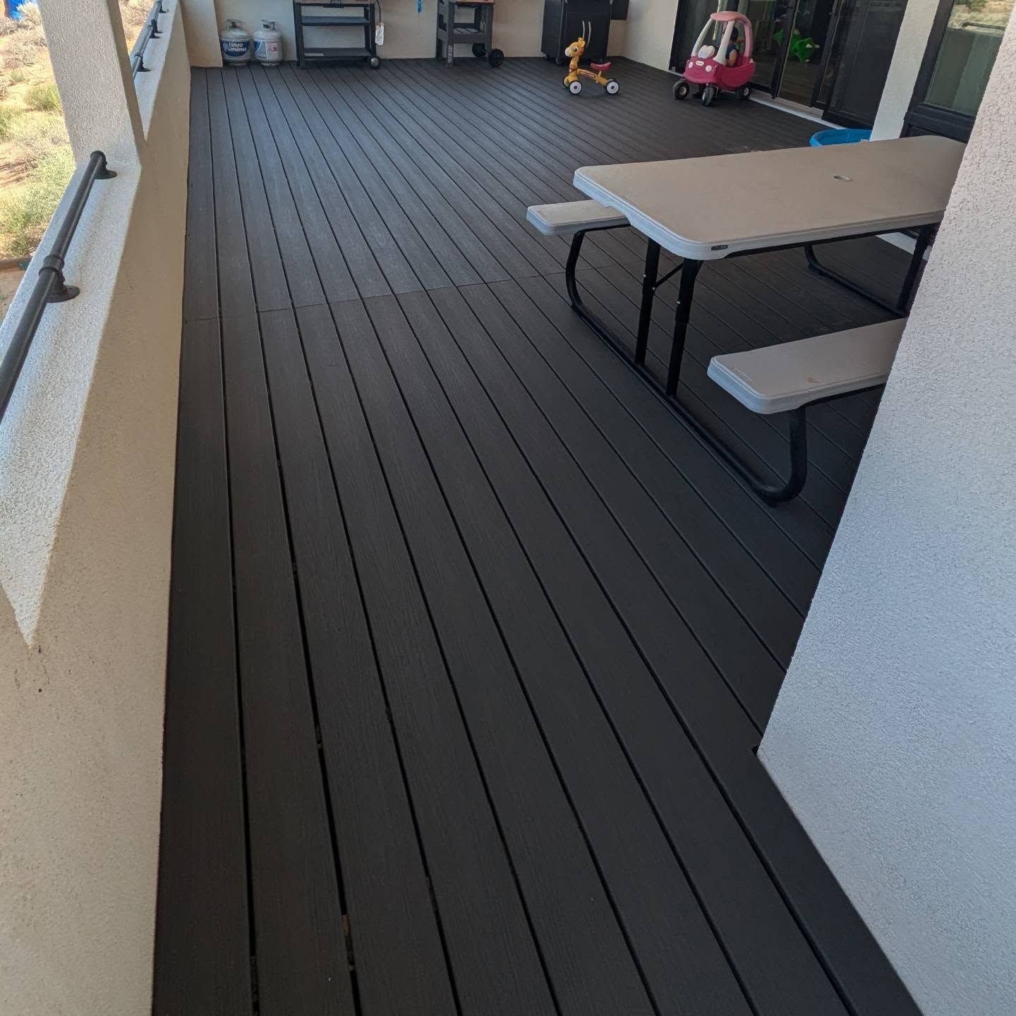 A black deck with a picnic table and benches