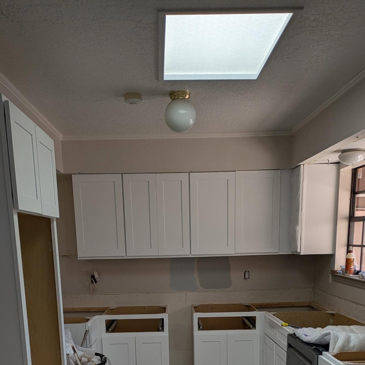 A kitchen with white cabinets and a light on the ceiling
