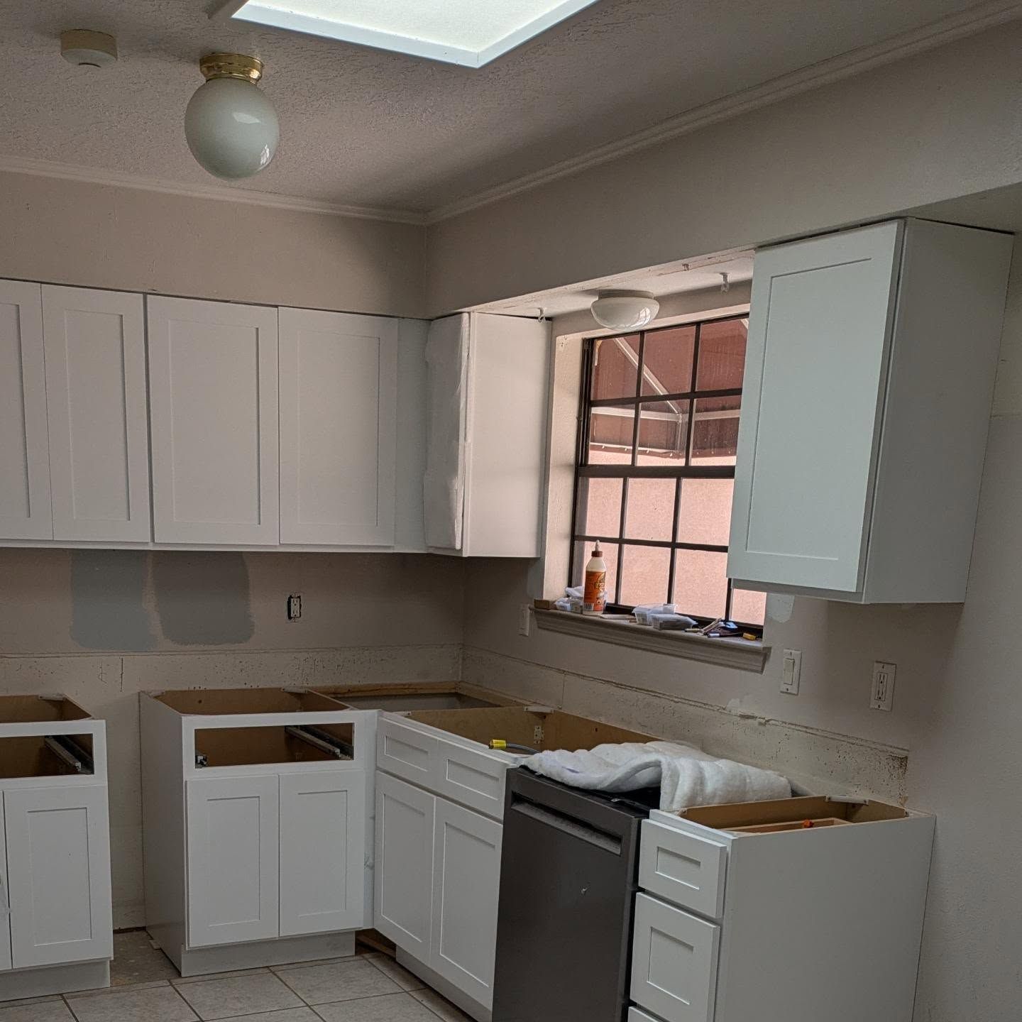A kitchen with white cabinets and a stainless steel dishwasher