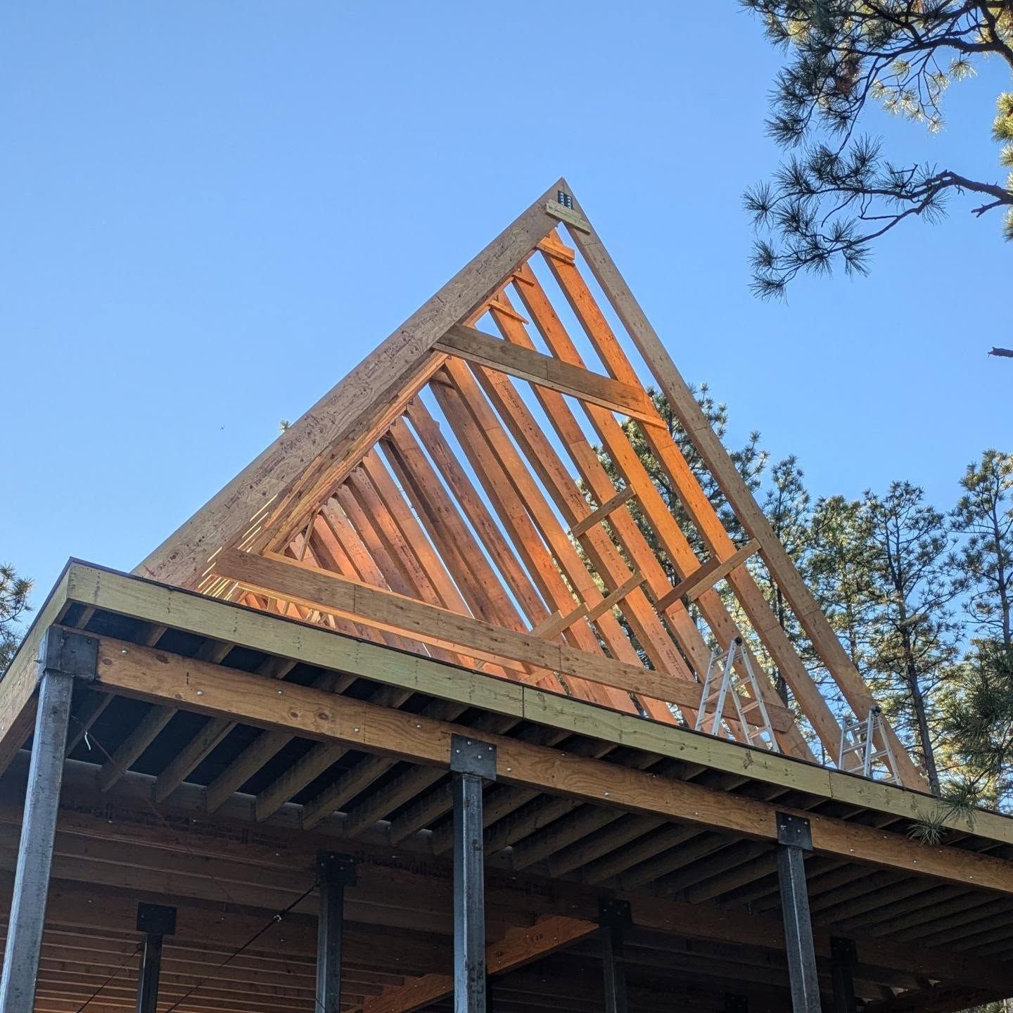 A wooden structure is being built with a triangle shaped roof.