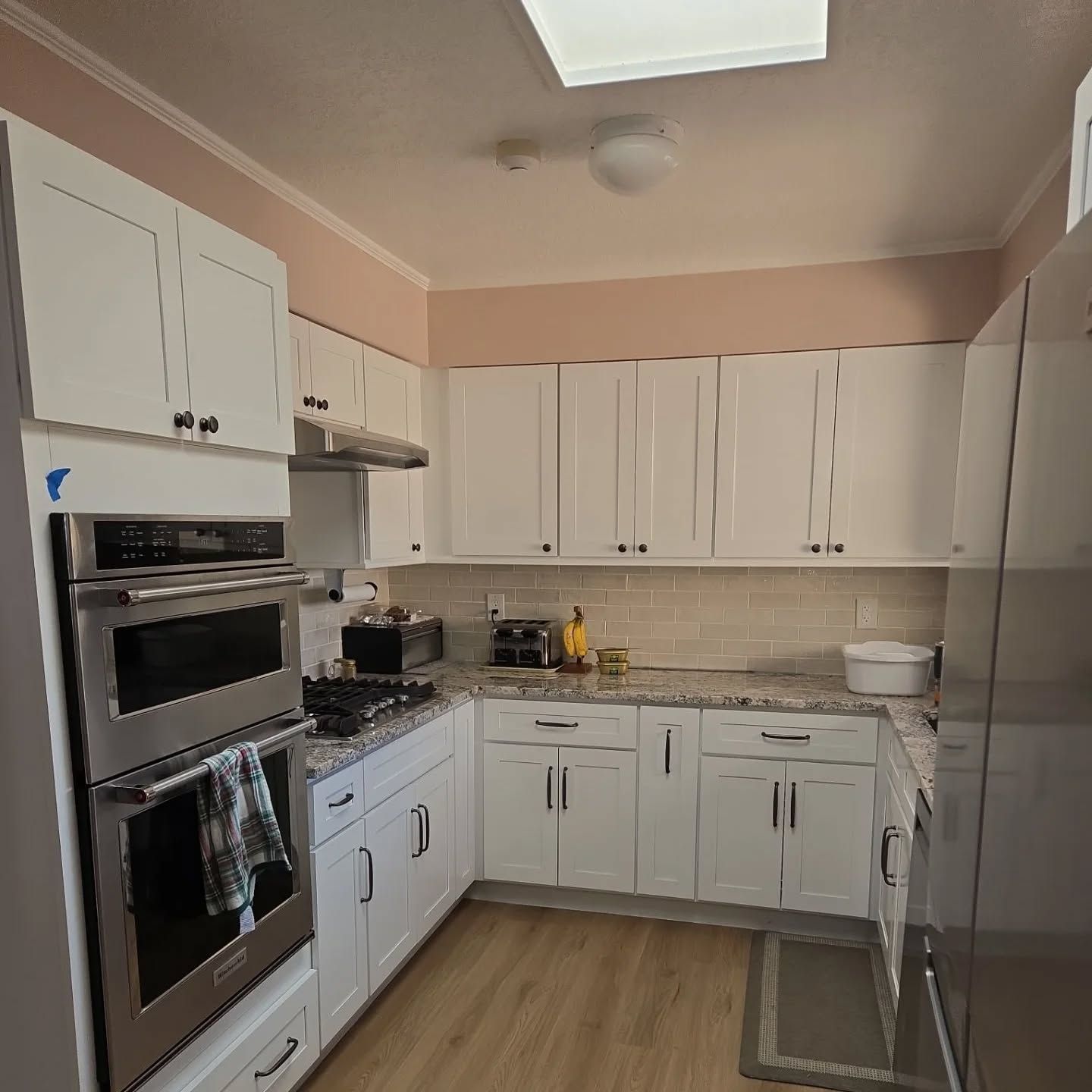 A kitchen with white cabinets and stainless steel appliances