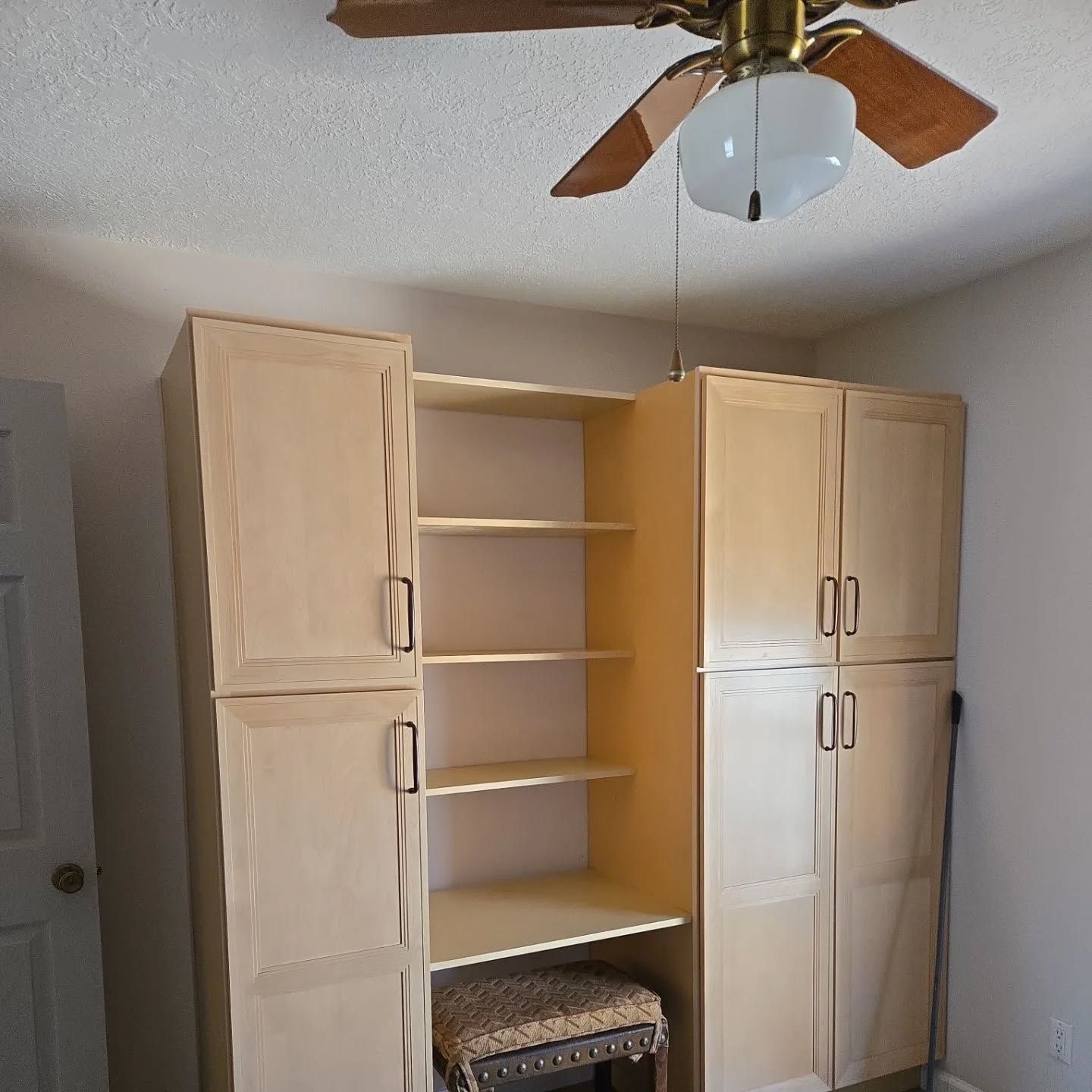 A ceiling fan is hanging from the ceiling above the cabinets