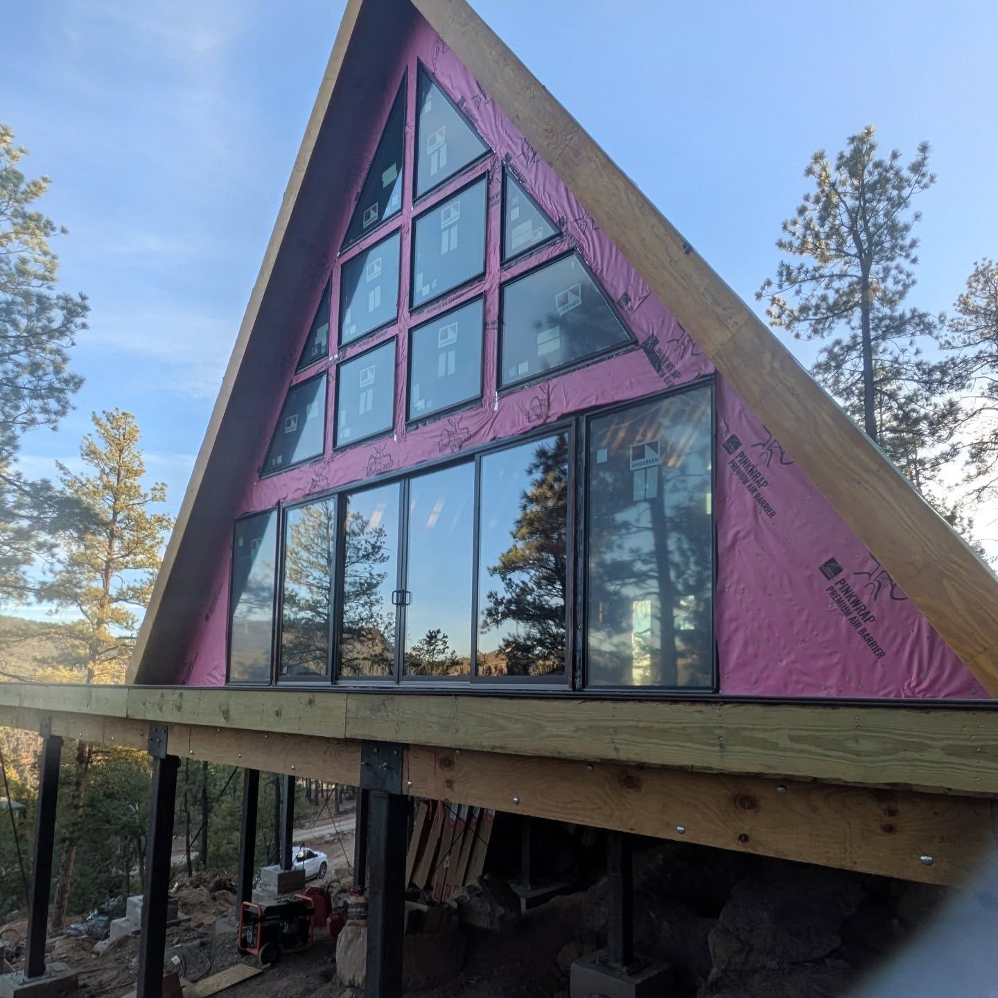 A triangle shaped house with a lot of windows