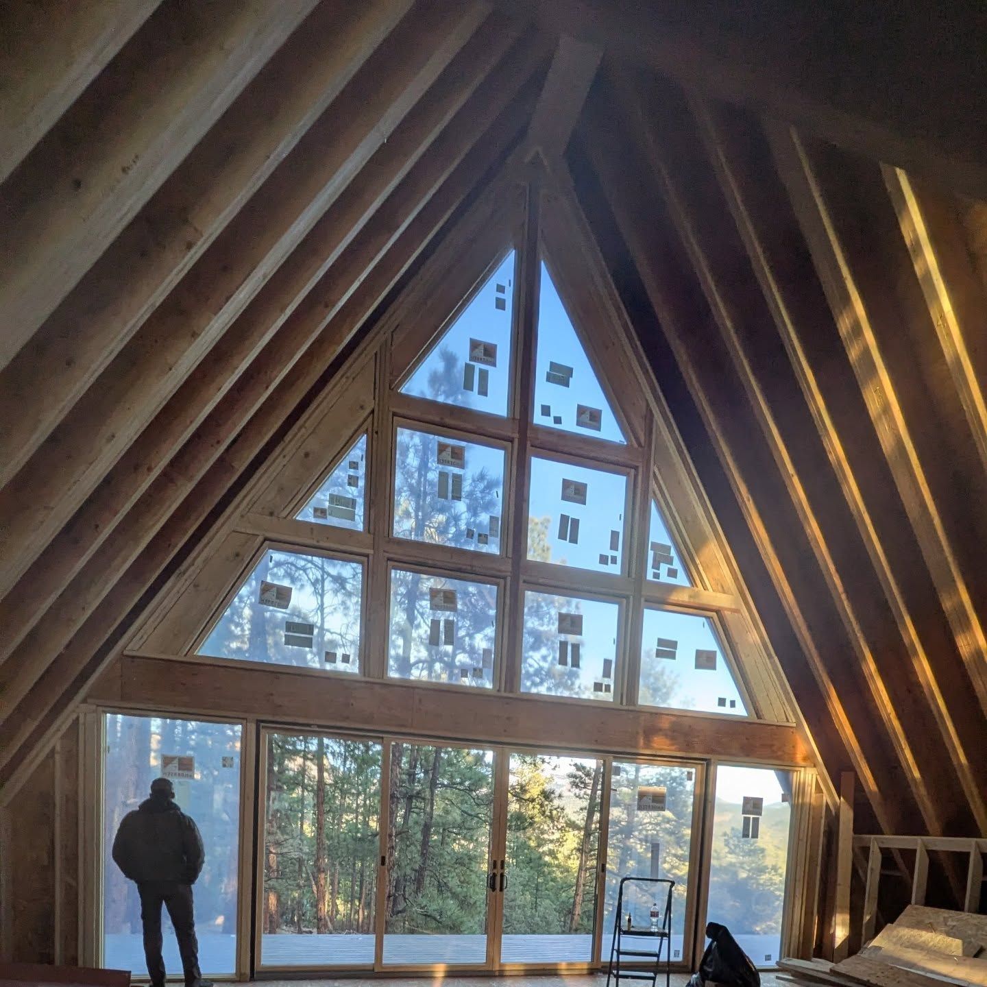 A man stands in a room with a lot of windows