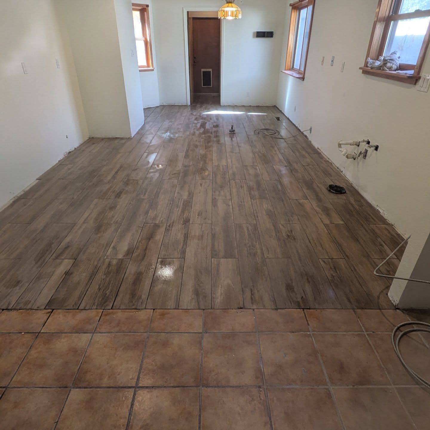 A room with a wooden floor and tile floor.