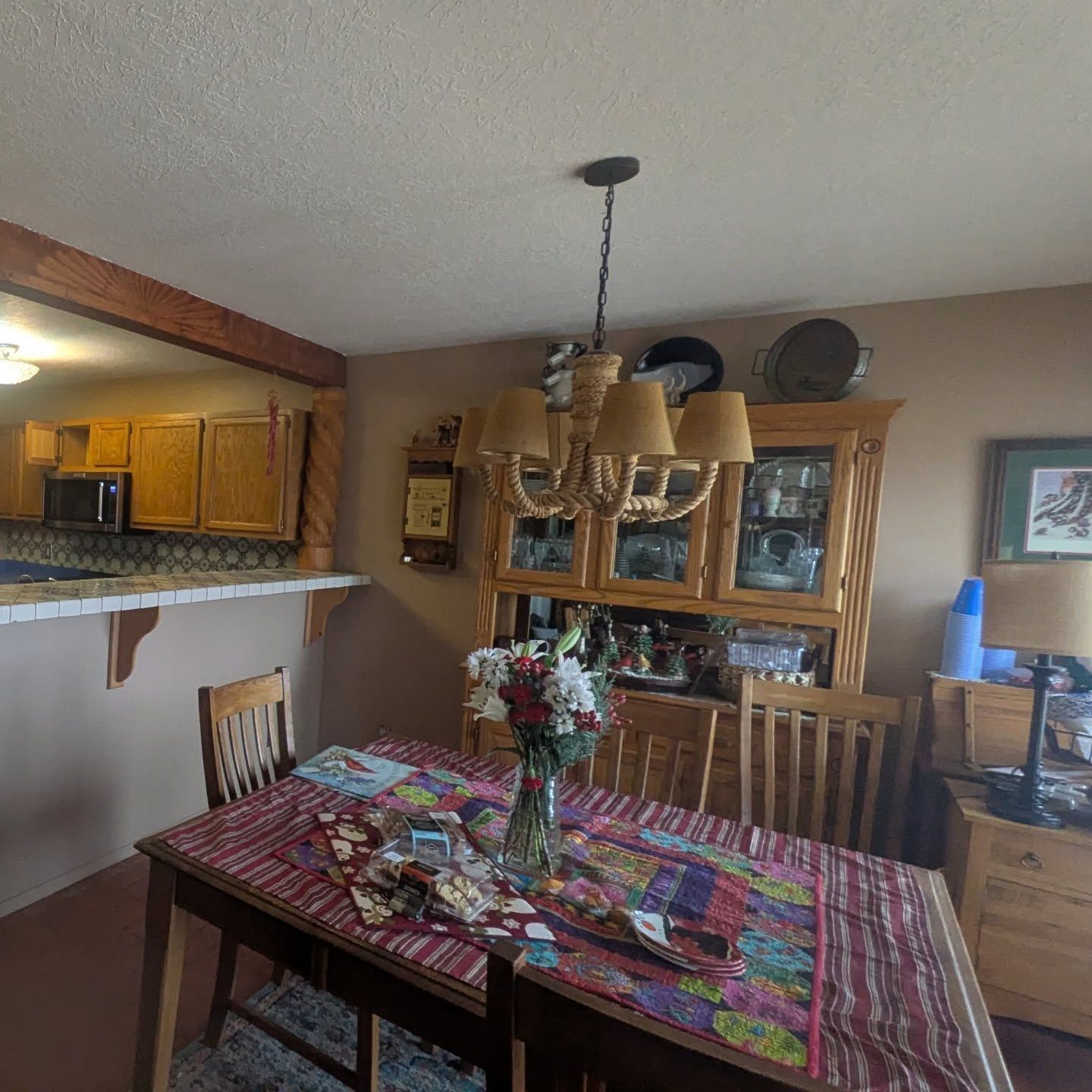 A dining room table with a vase of flowers on it