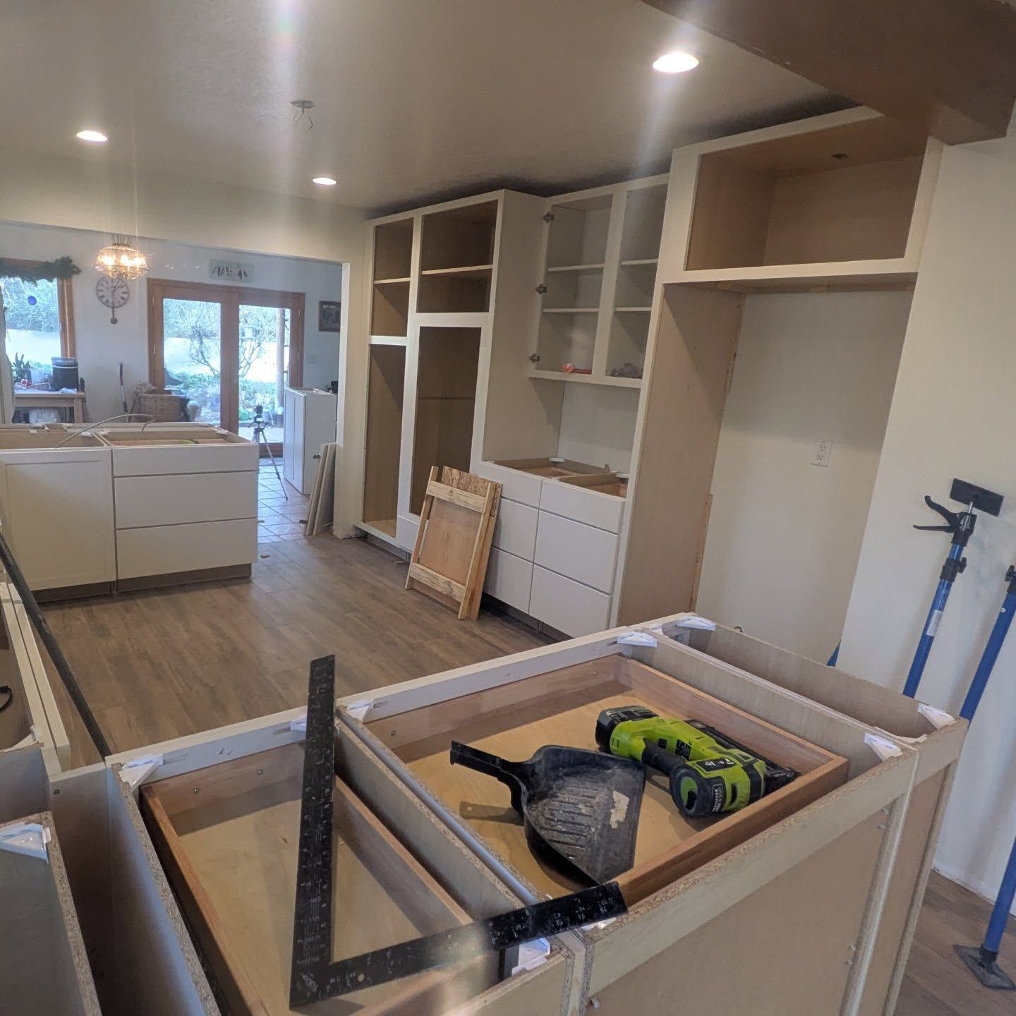A drill is sitting on top of a box in a kitchen under construction.