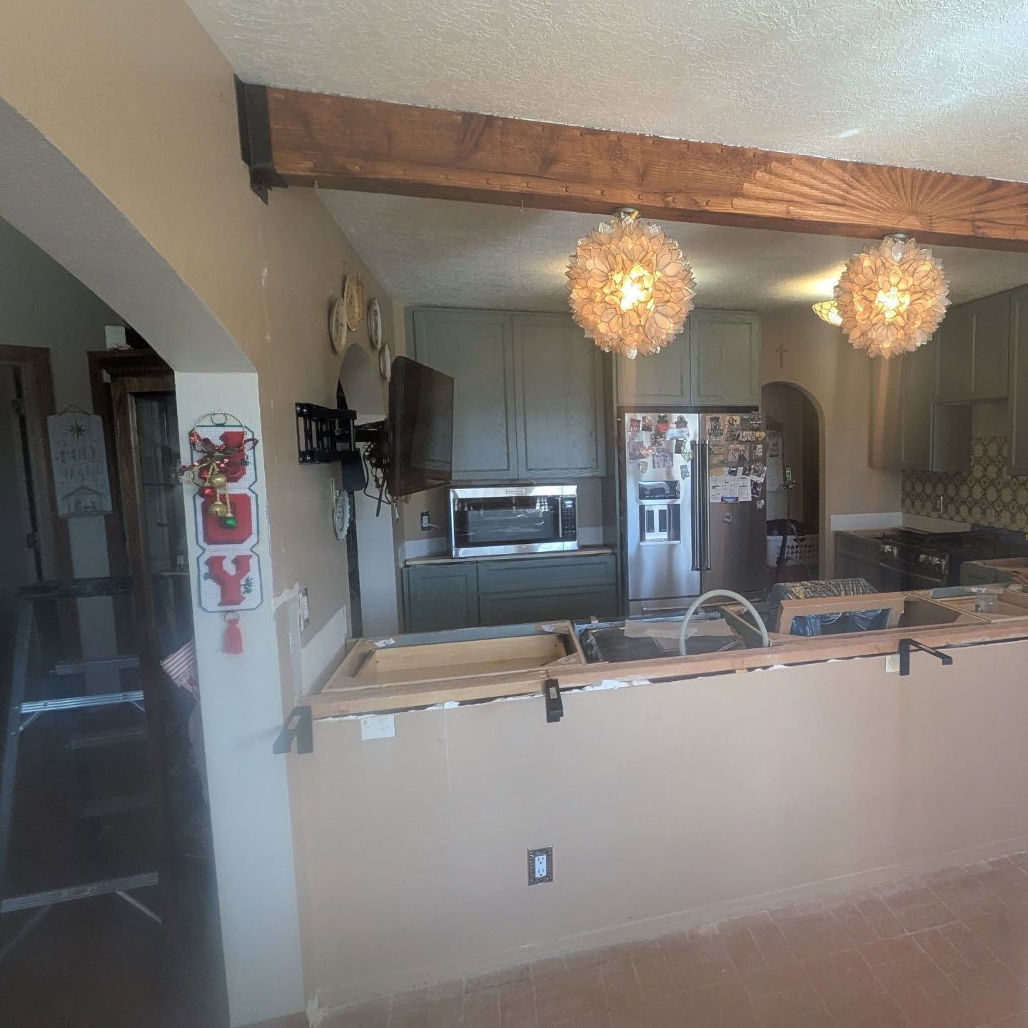 A kitchen with a stainless steel refrigerator and a sink