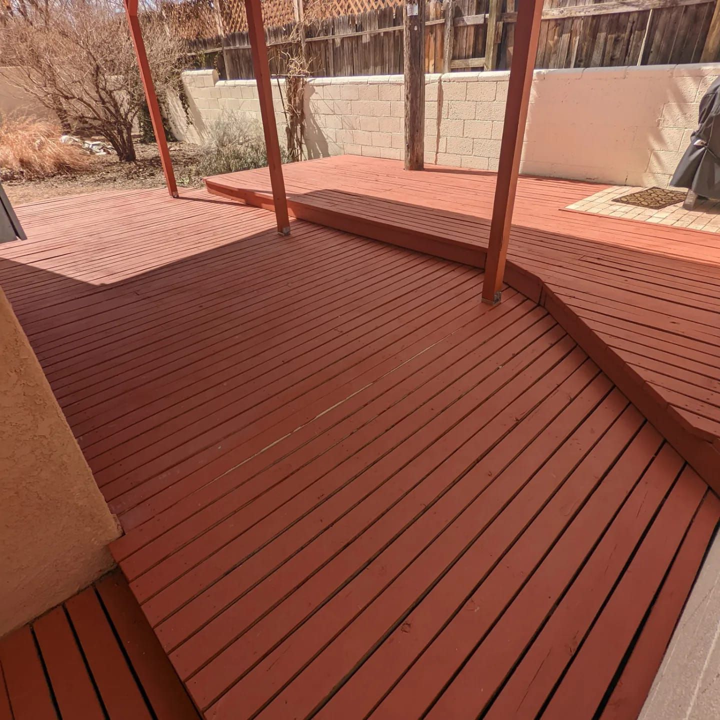 A wooden deck with a fence in the background