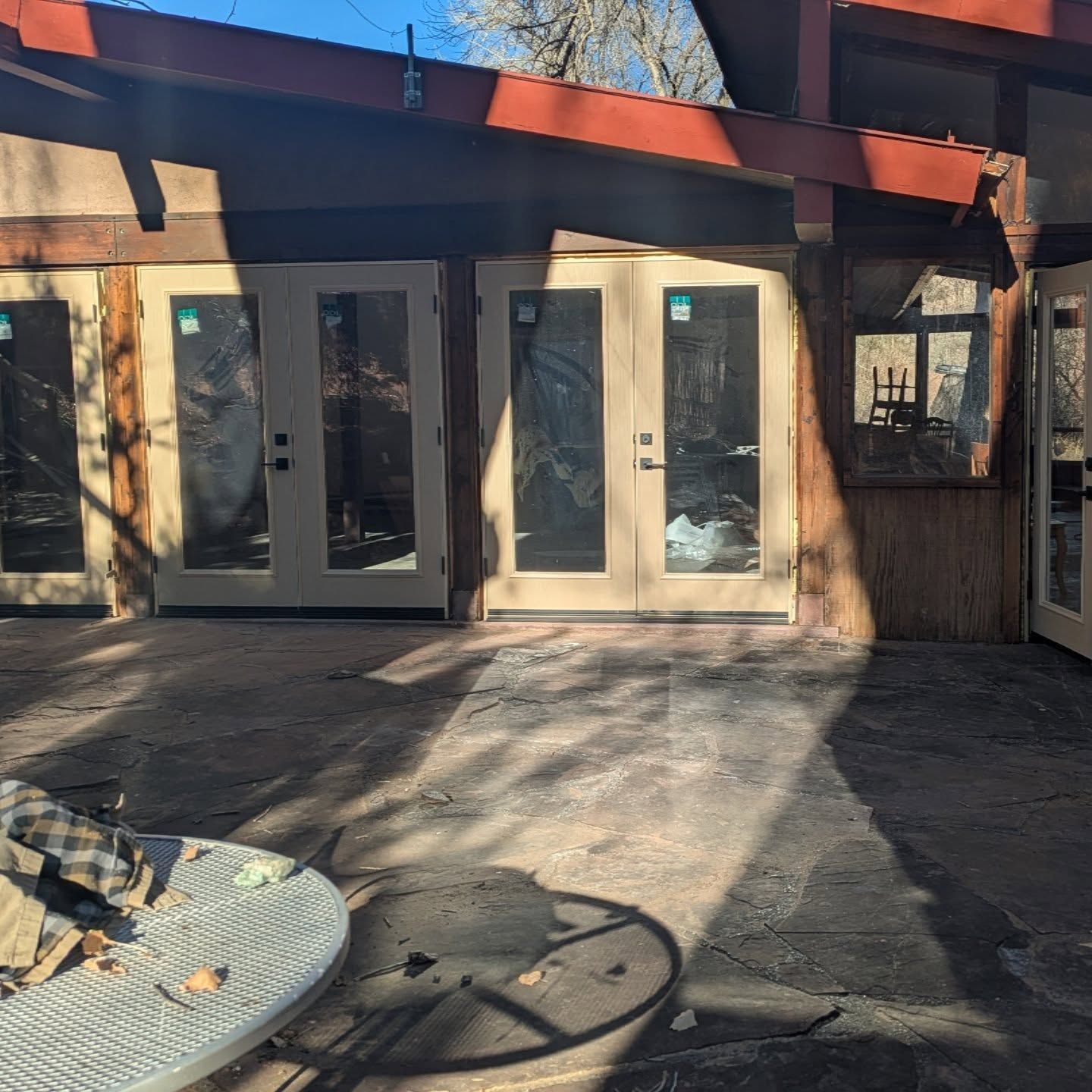 A patio with a table and chairs in front of a house
