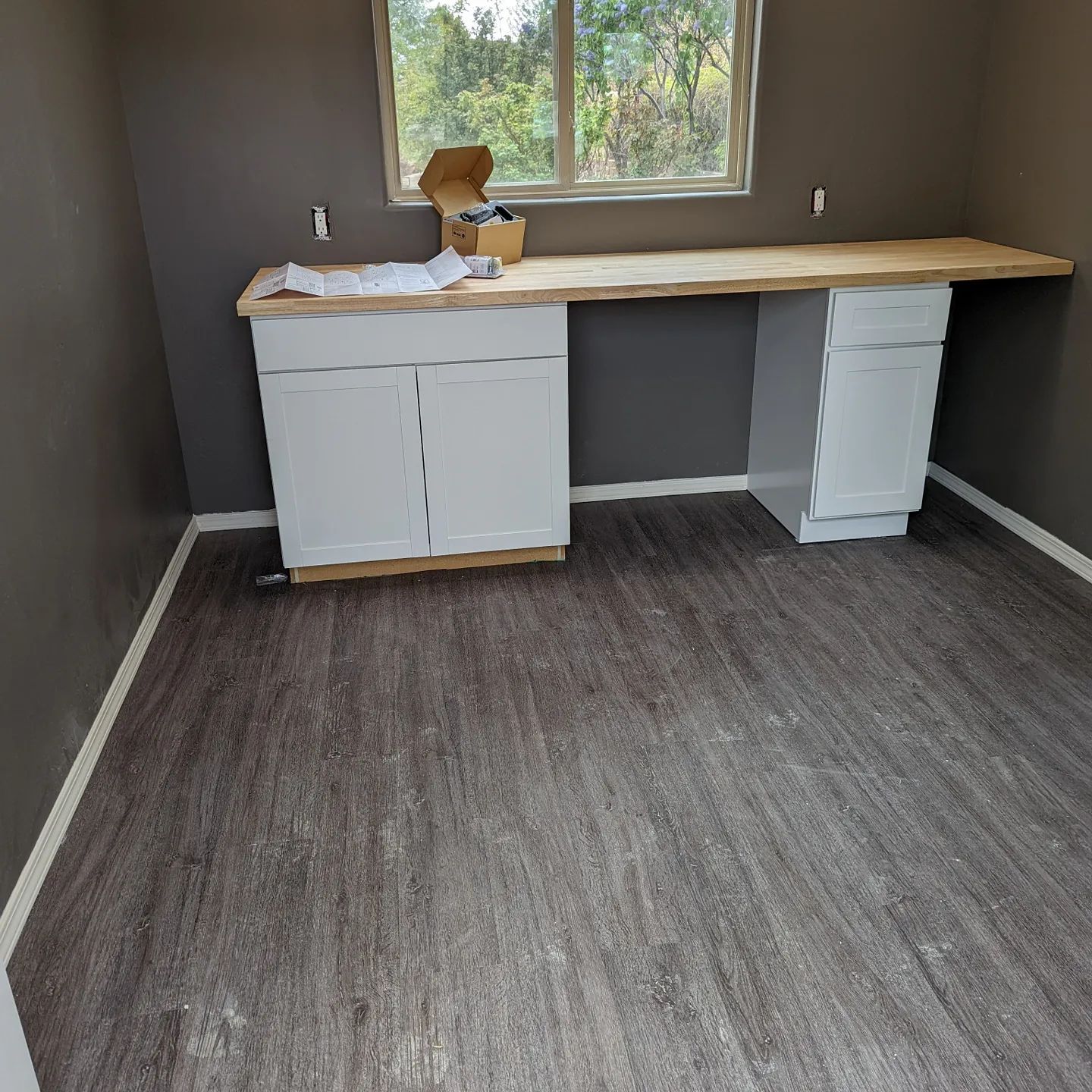An empty room with a wooden desk and cabinets