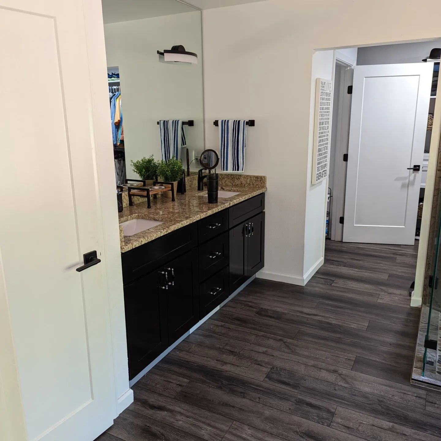A bathroom with black cabinets and a large mirror