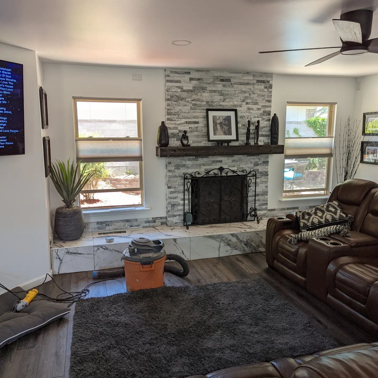 A living room with a fireplace and a tv on the wall