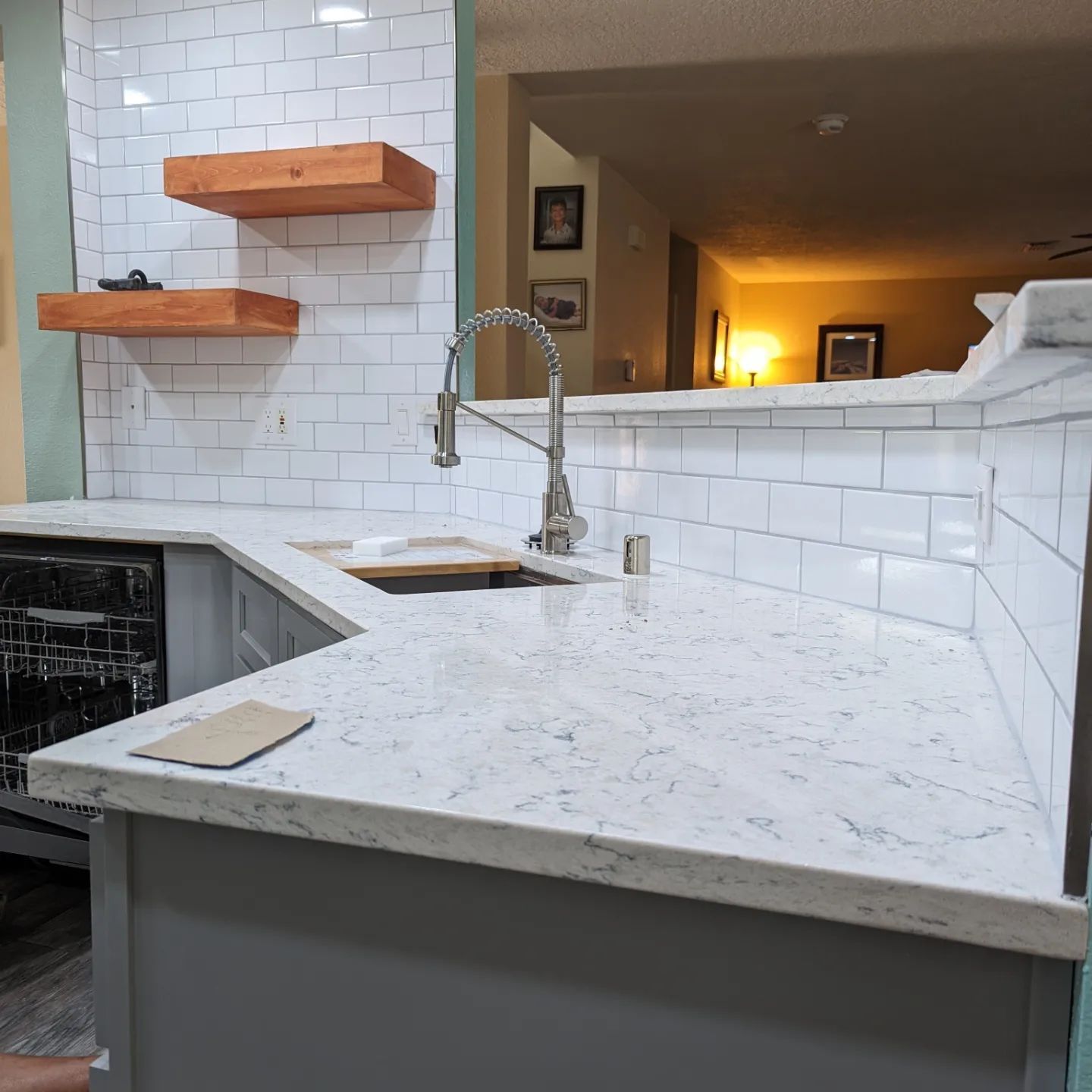 A kitchen with white counter tops and a sink