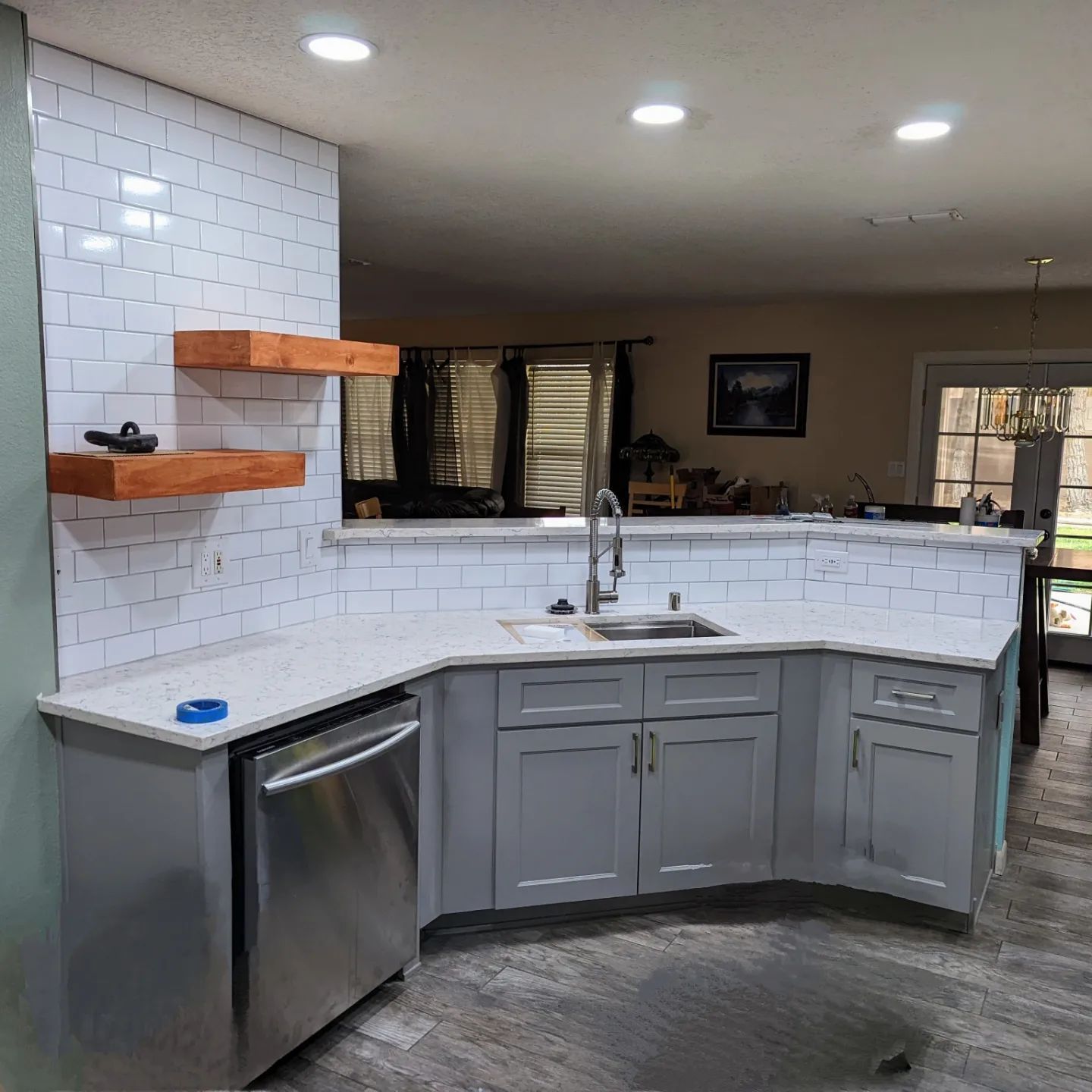 A kitchen with white cabinets and a stainless steel dishwasher