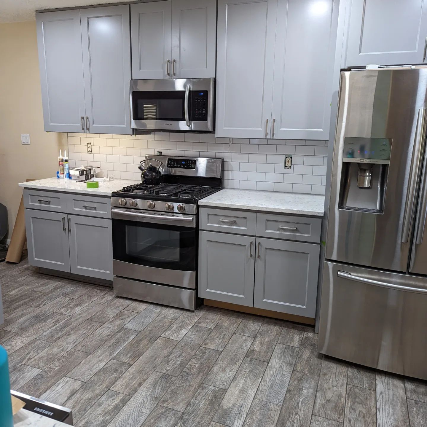 A kitchen with stainless steel appliances and gray cabinets