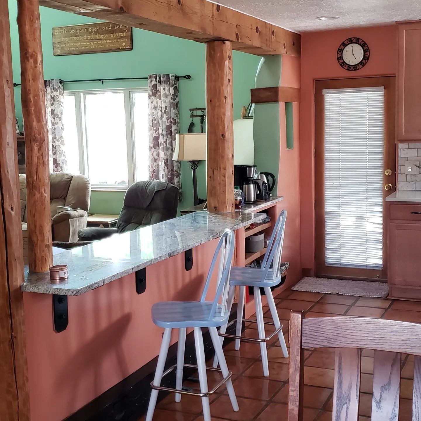 A kitchen with a table and chairs and a clock on the wall