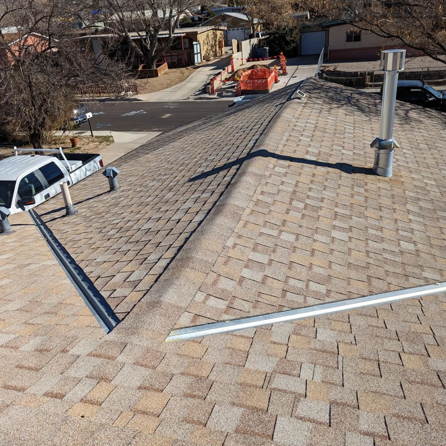 A white truck is parked on the roof of a house