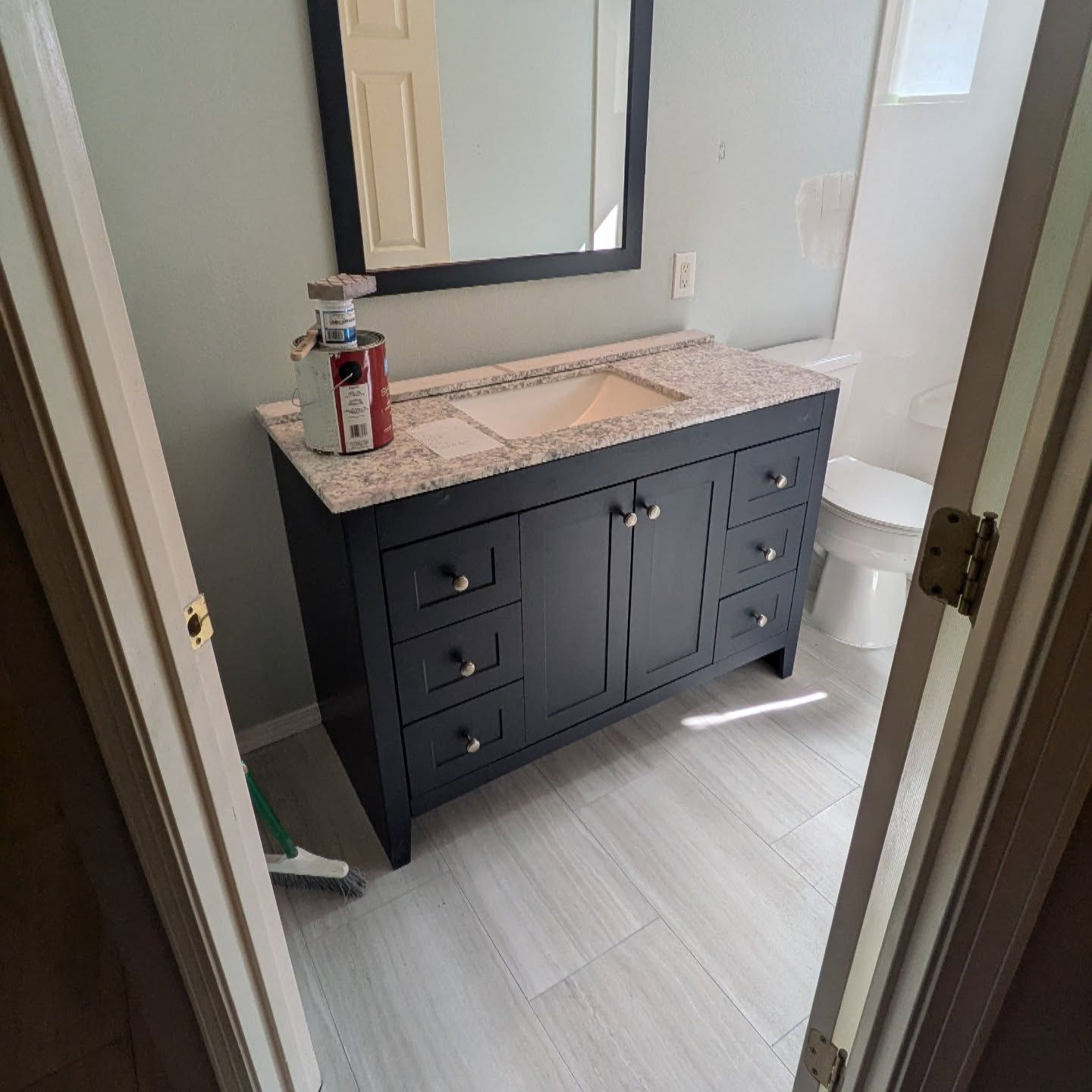 A bathroom with a sink , mirror and toilet.