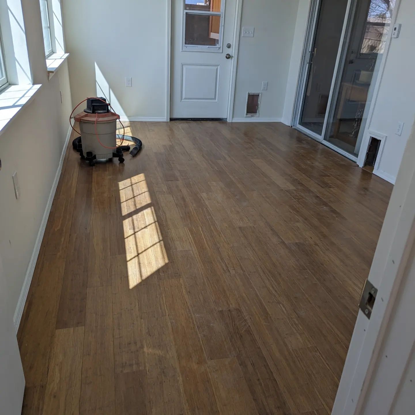 A room with hardwood floors and a vacuum cleaner on the floor