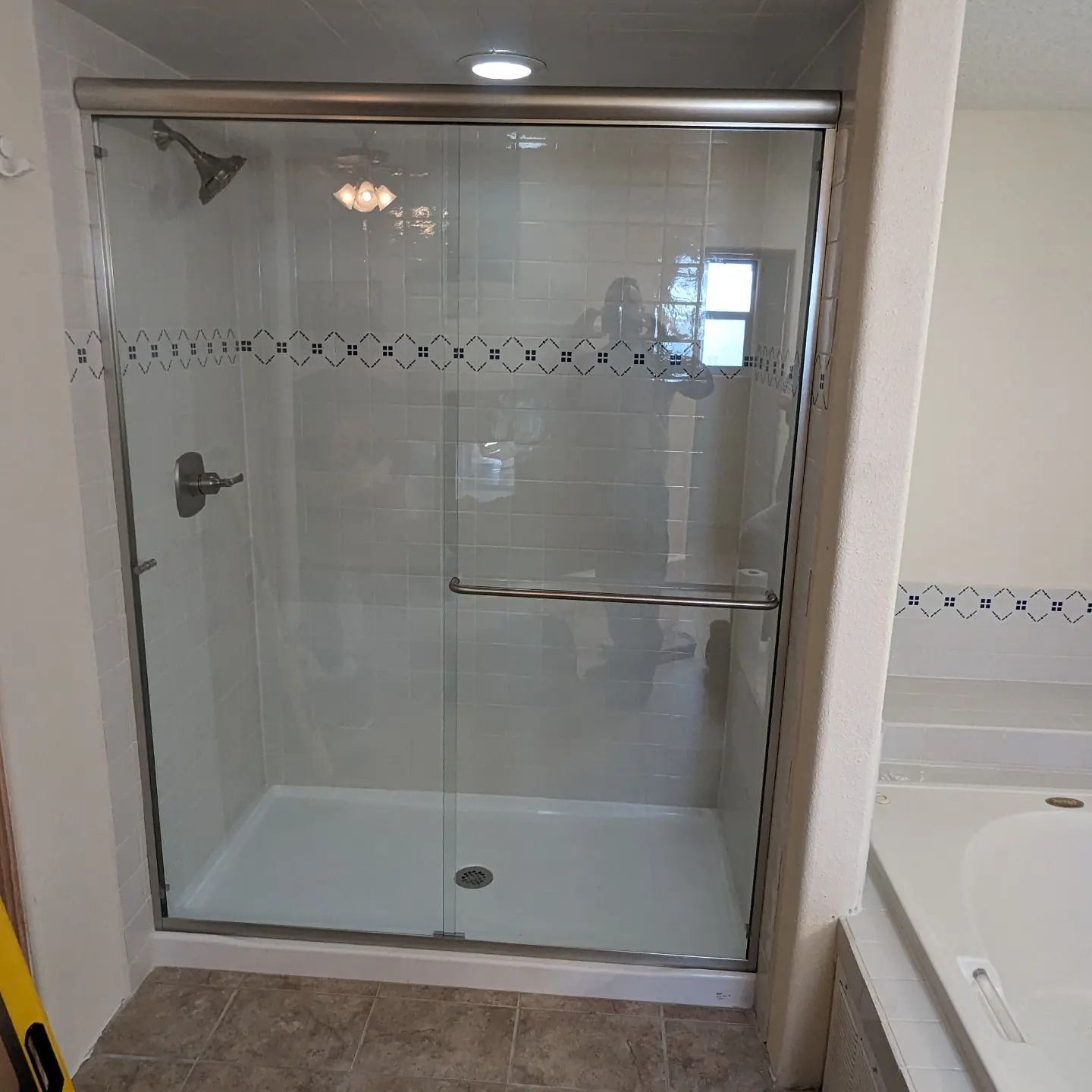 A bathroom with a sliding glass shower door and a bathtub.
