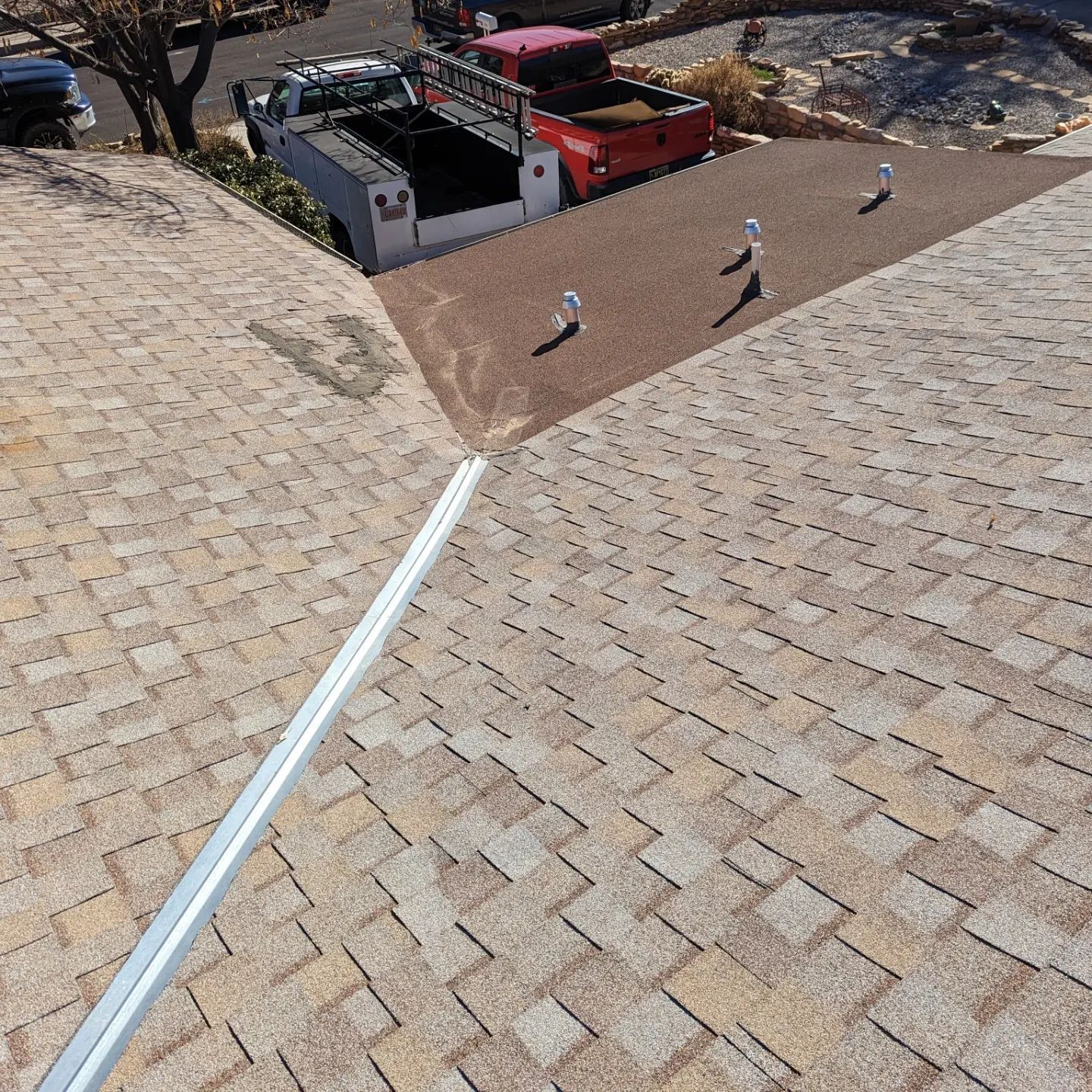 A red truck is parked on the roof of a house.