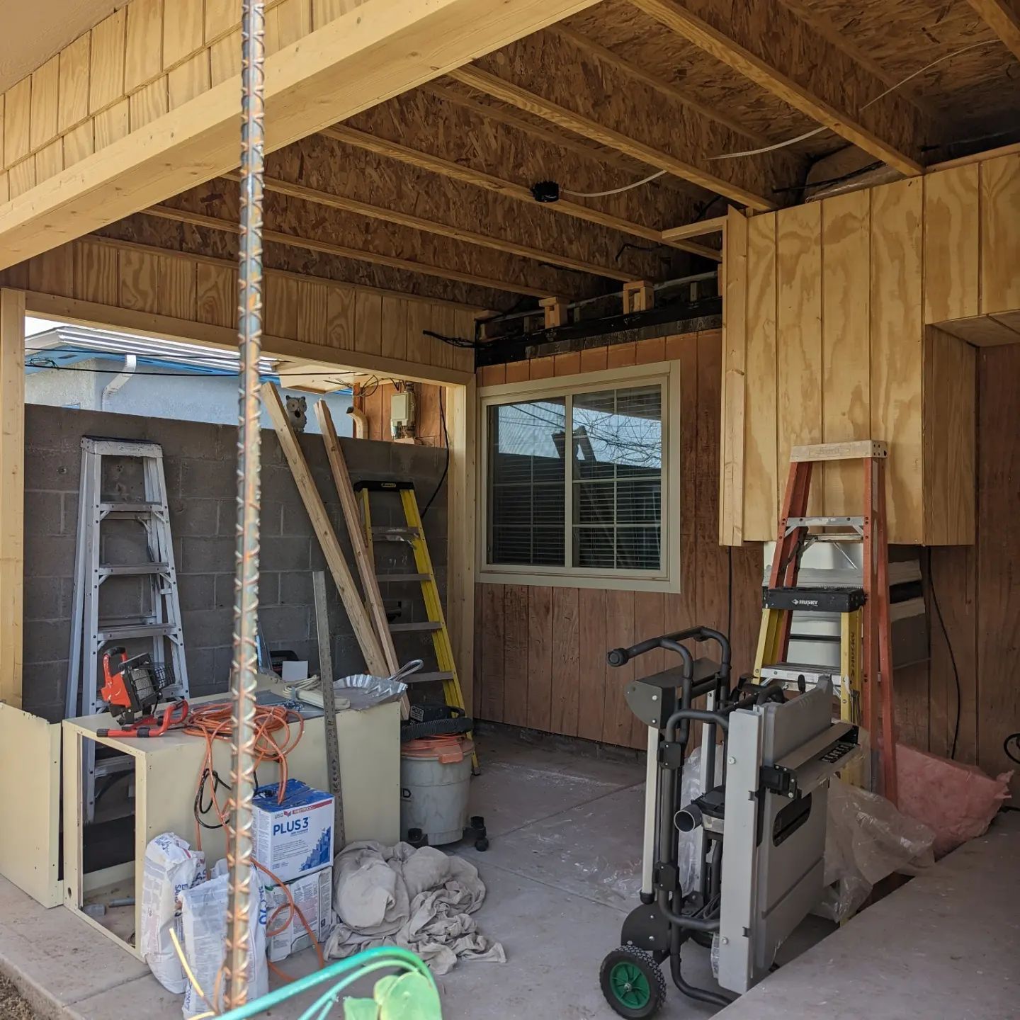 A building under construction with tools and a ladder