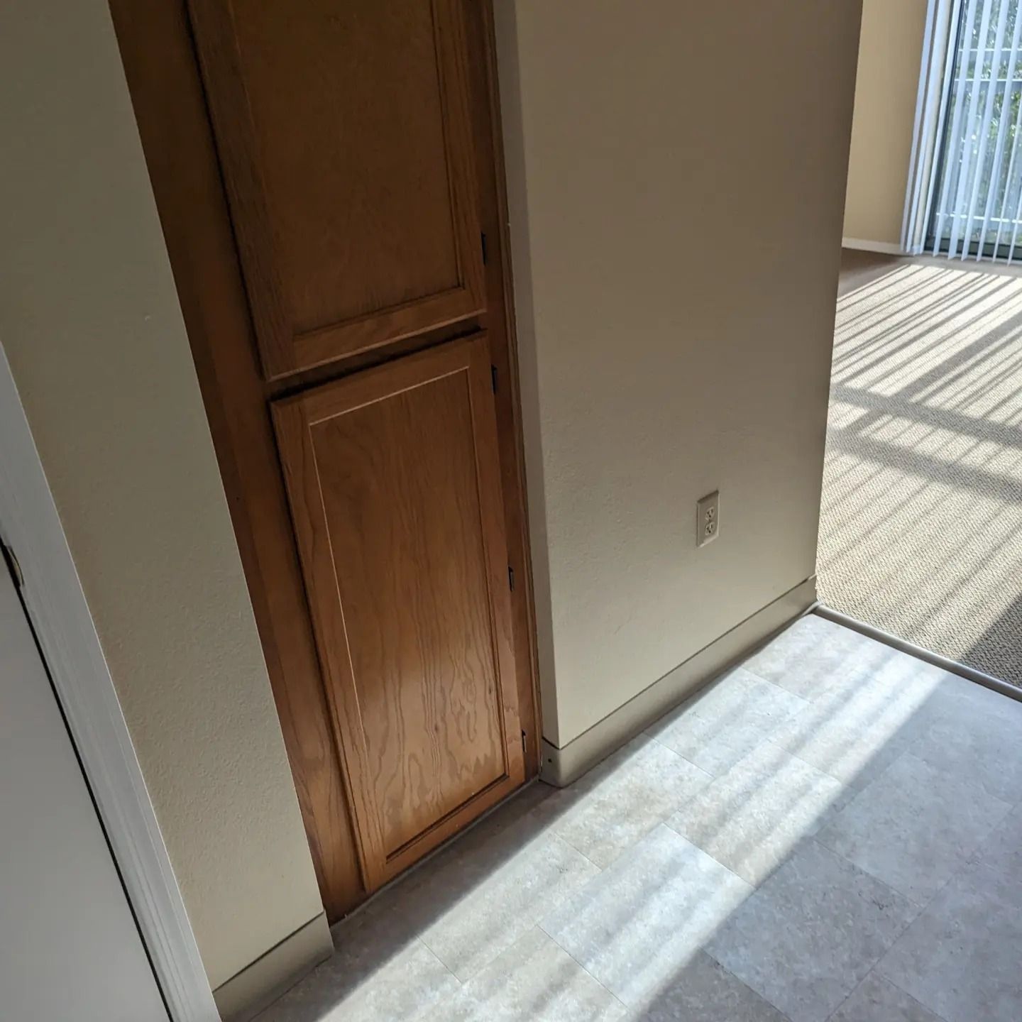 A hallway with a wooden door and a sliding glass door
