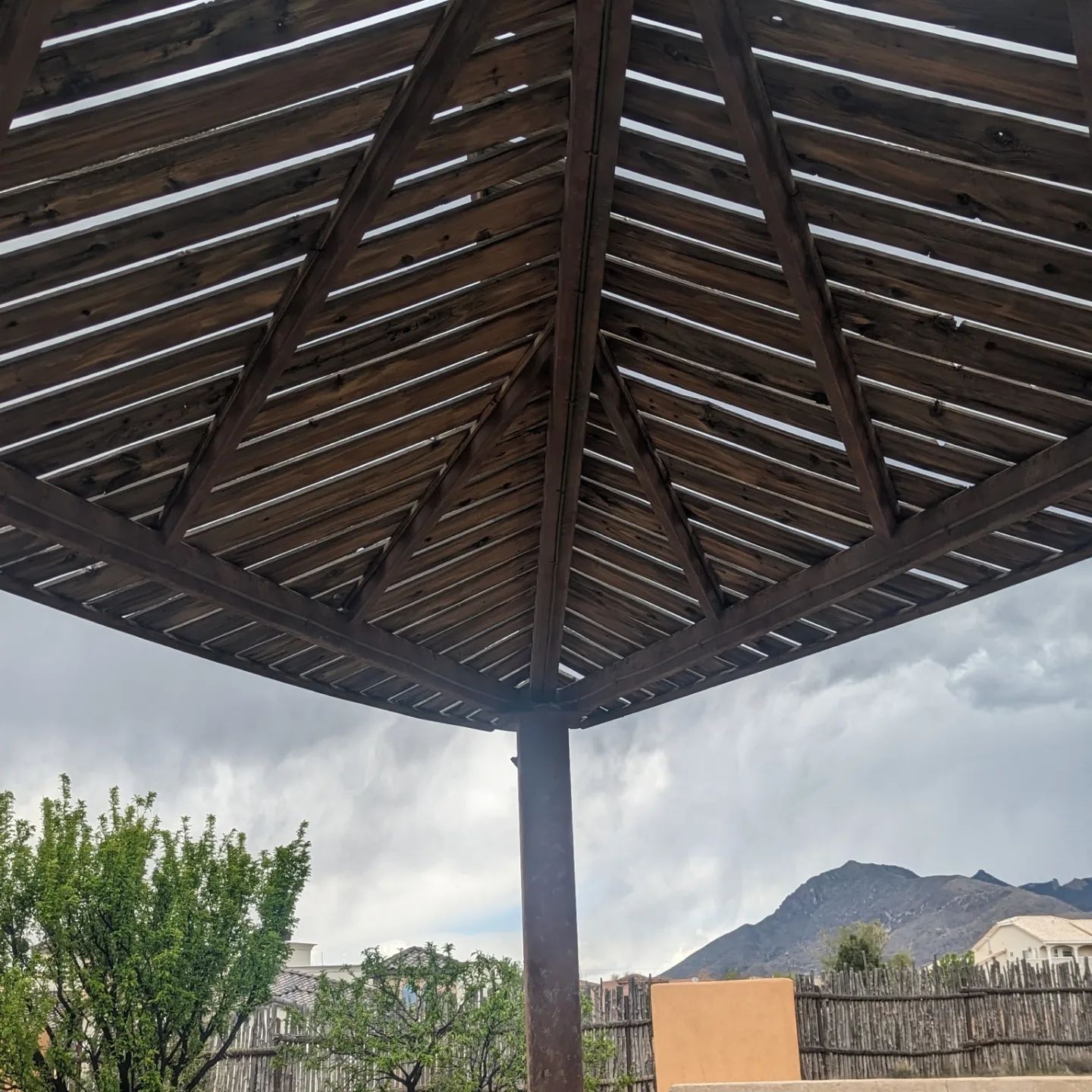 The roof of a wooden structure with mountains in the background