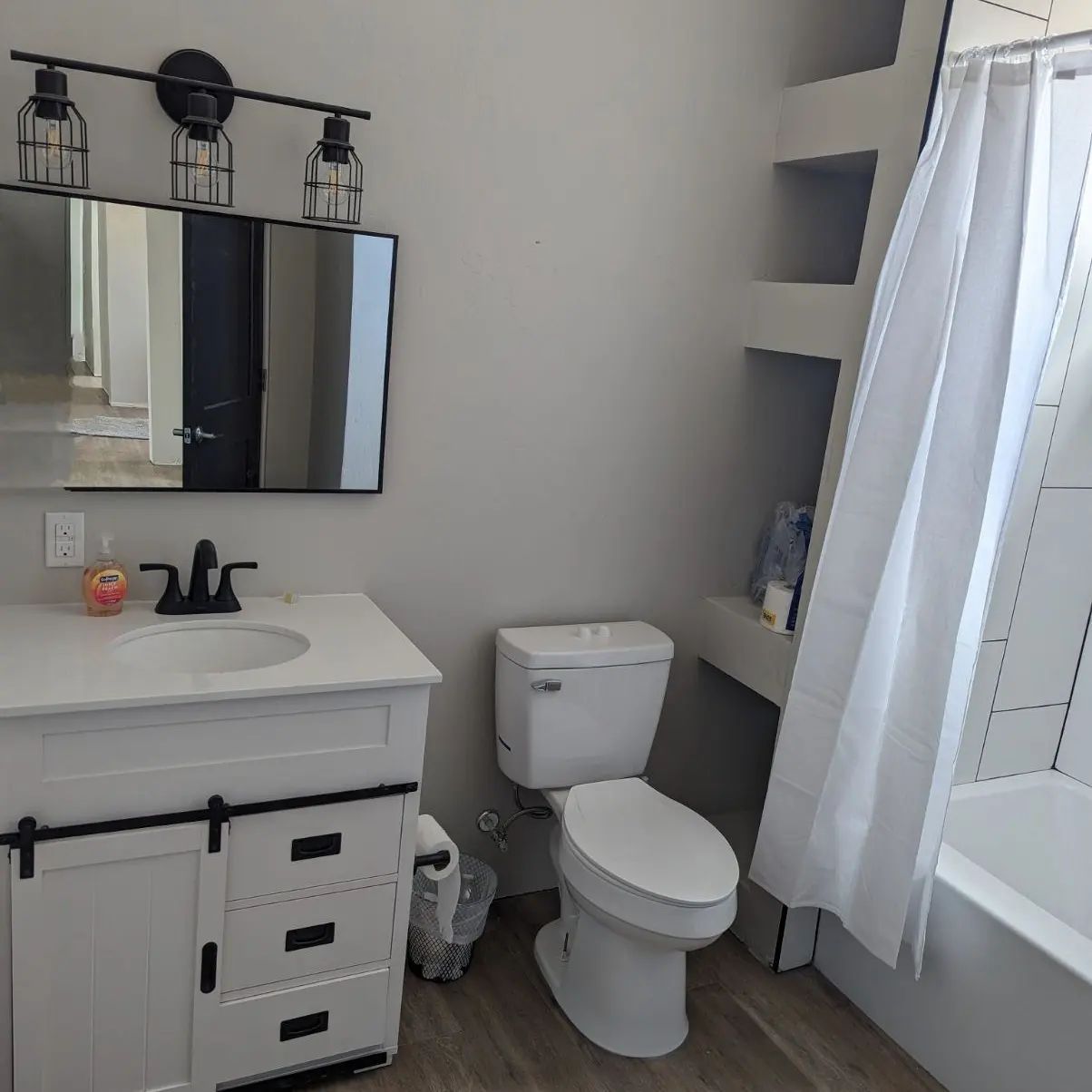 A bathroom with a toilet , sink and mirror