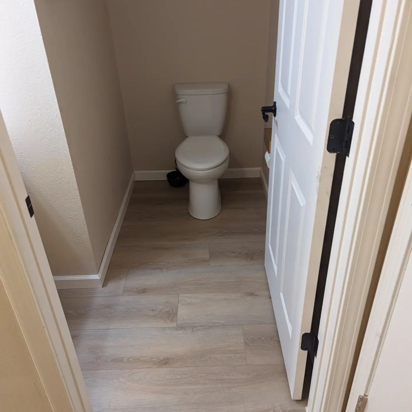 A bathroom with a toilet and a white door