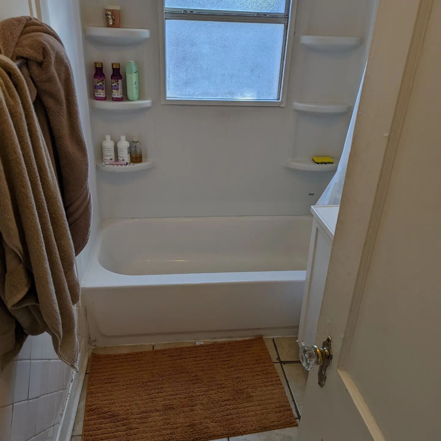 A bathroom with a bathtub and a rug on the floor