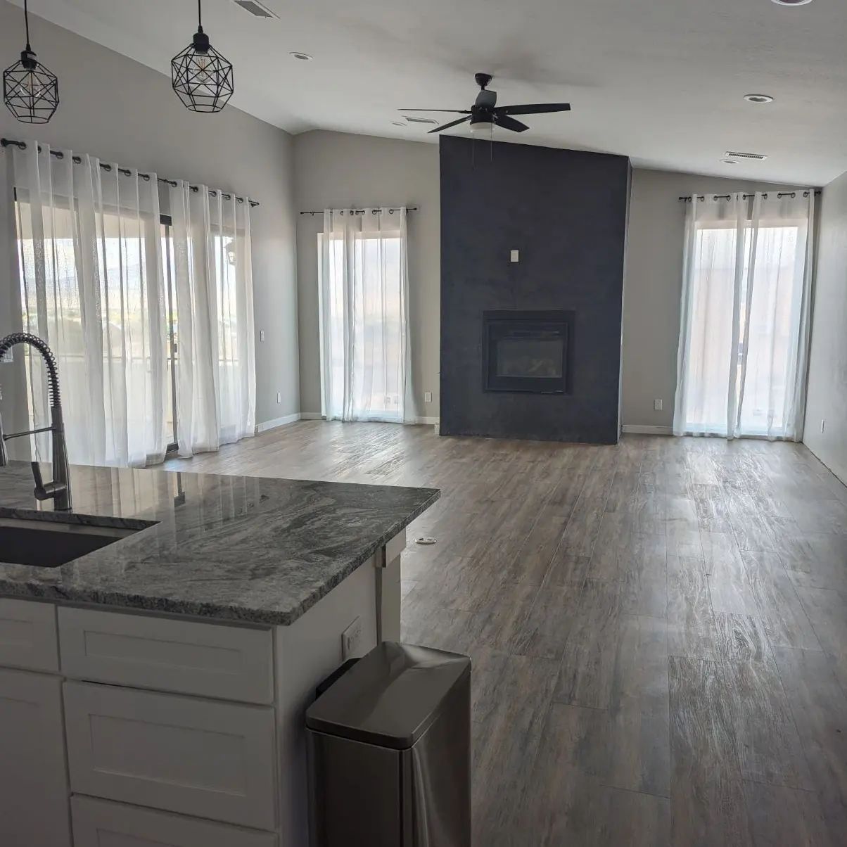 A living room with a fireplace and a ceiling fan