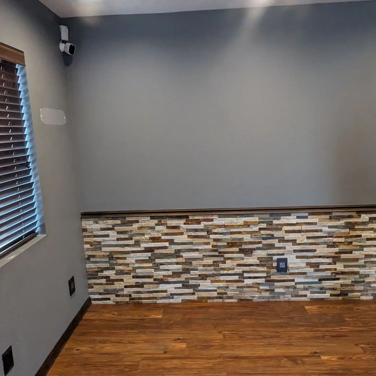 An empty room with a stone wall and a window