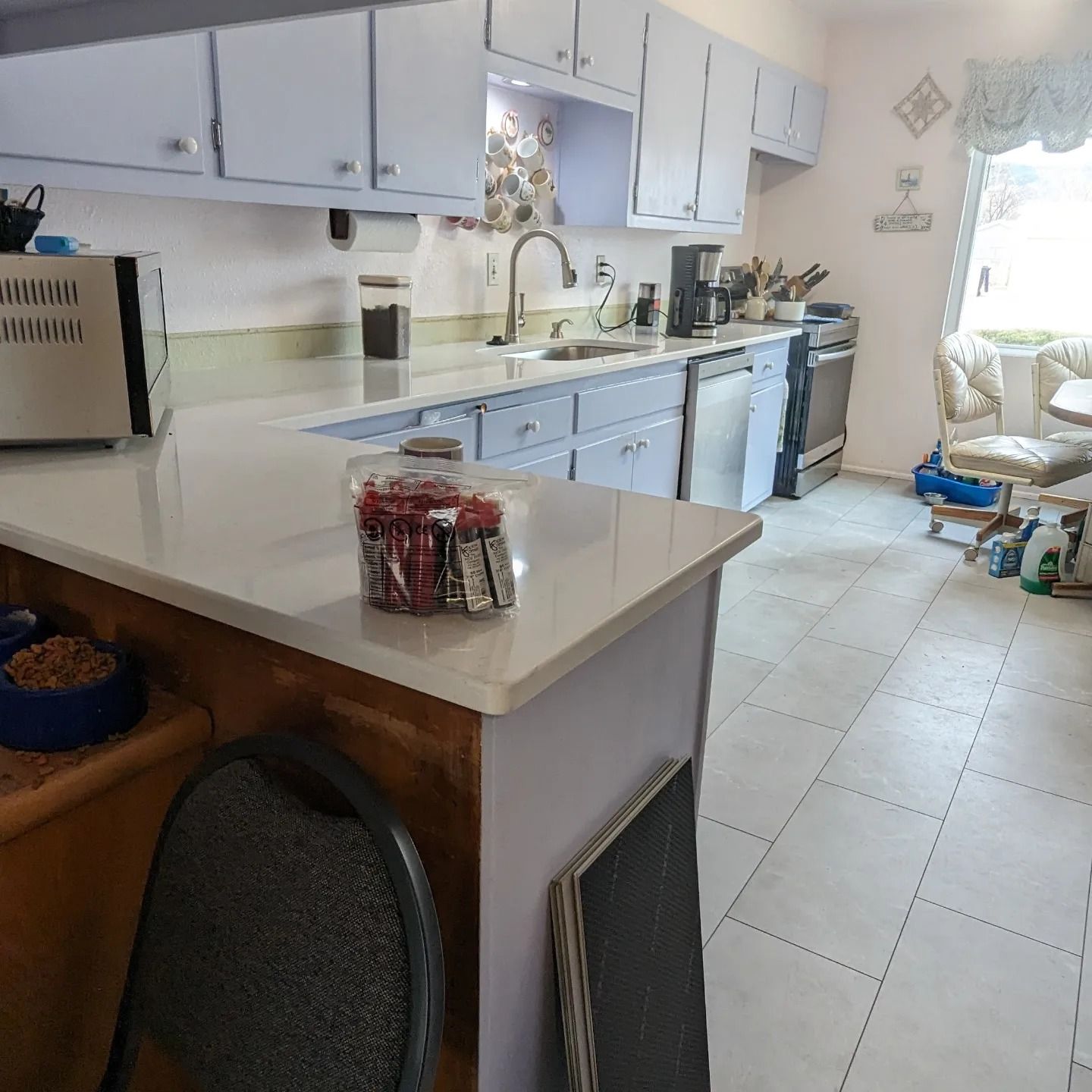 A kitchen with white cabinets and a jar of food on the counter